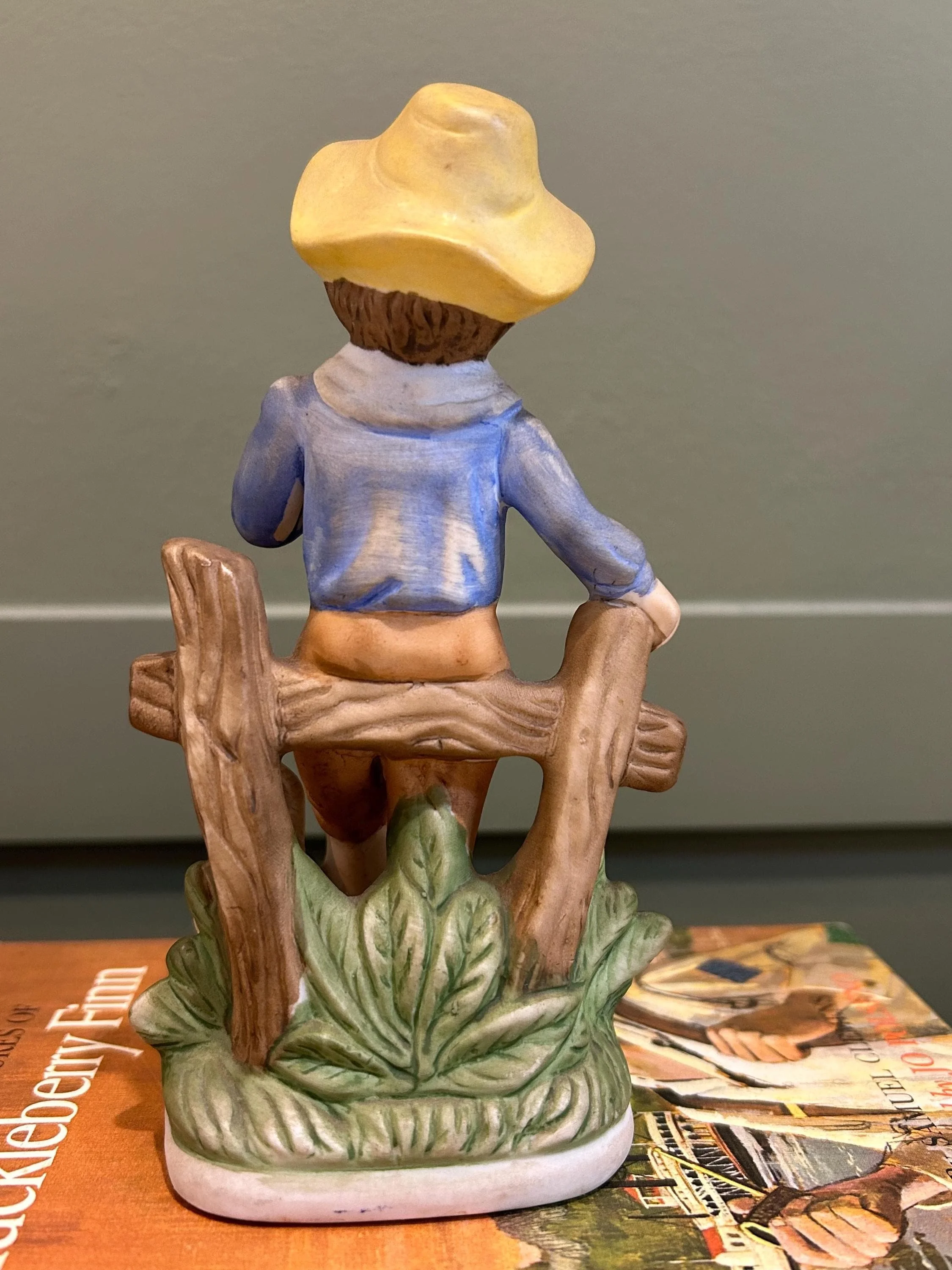 Rear view showing boy’s back, fence, and base detailing