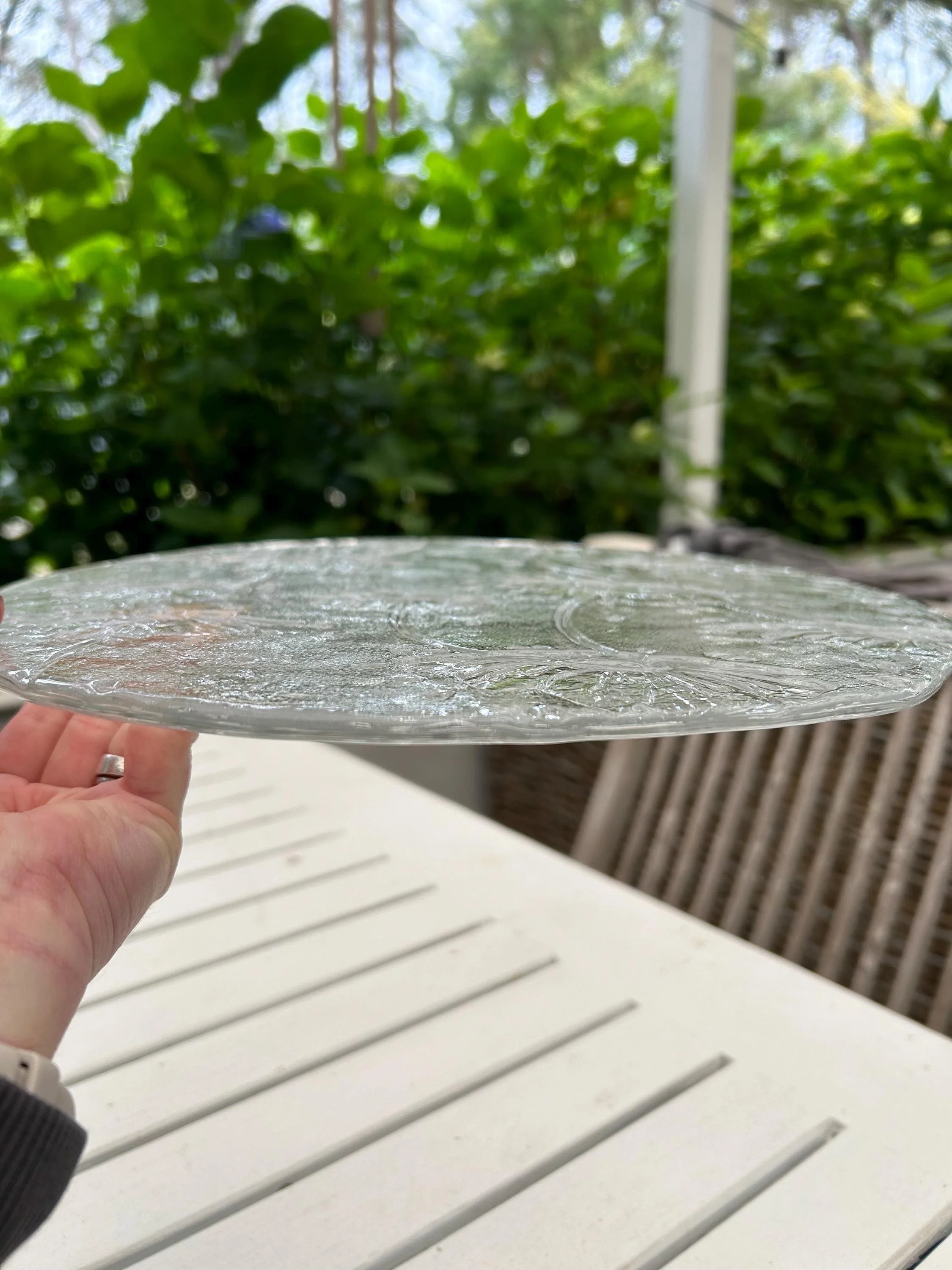 Side profile view of Italian pressed glass platter showing embossed detailing and transparency