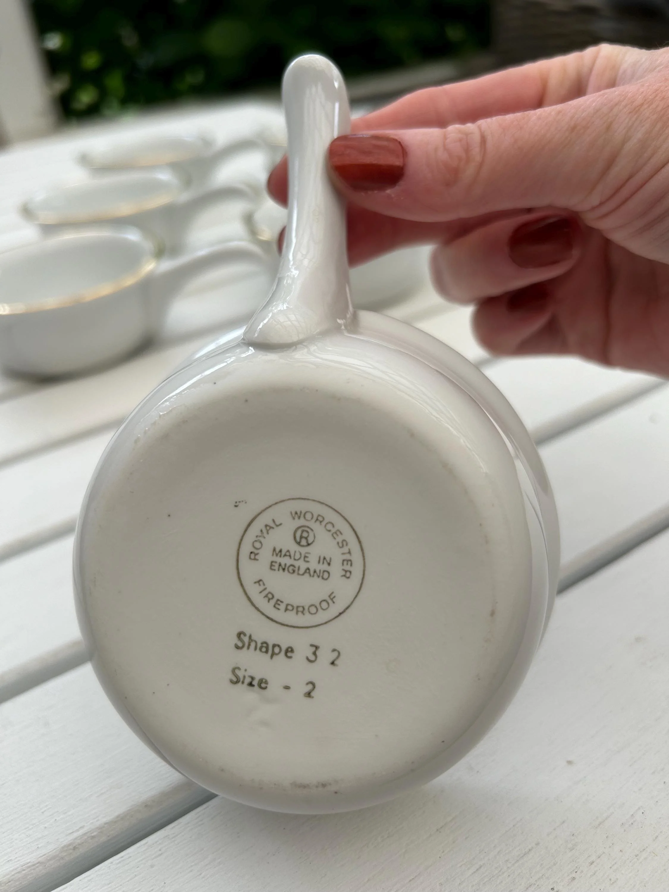 Detail of handle and gold accent in hand, highlighting vintage glaze and craftsmanship