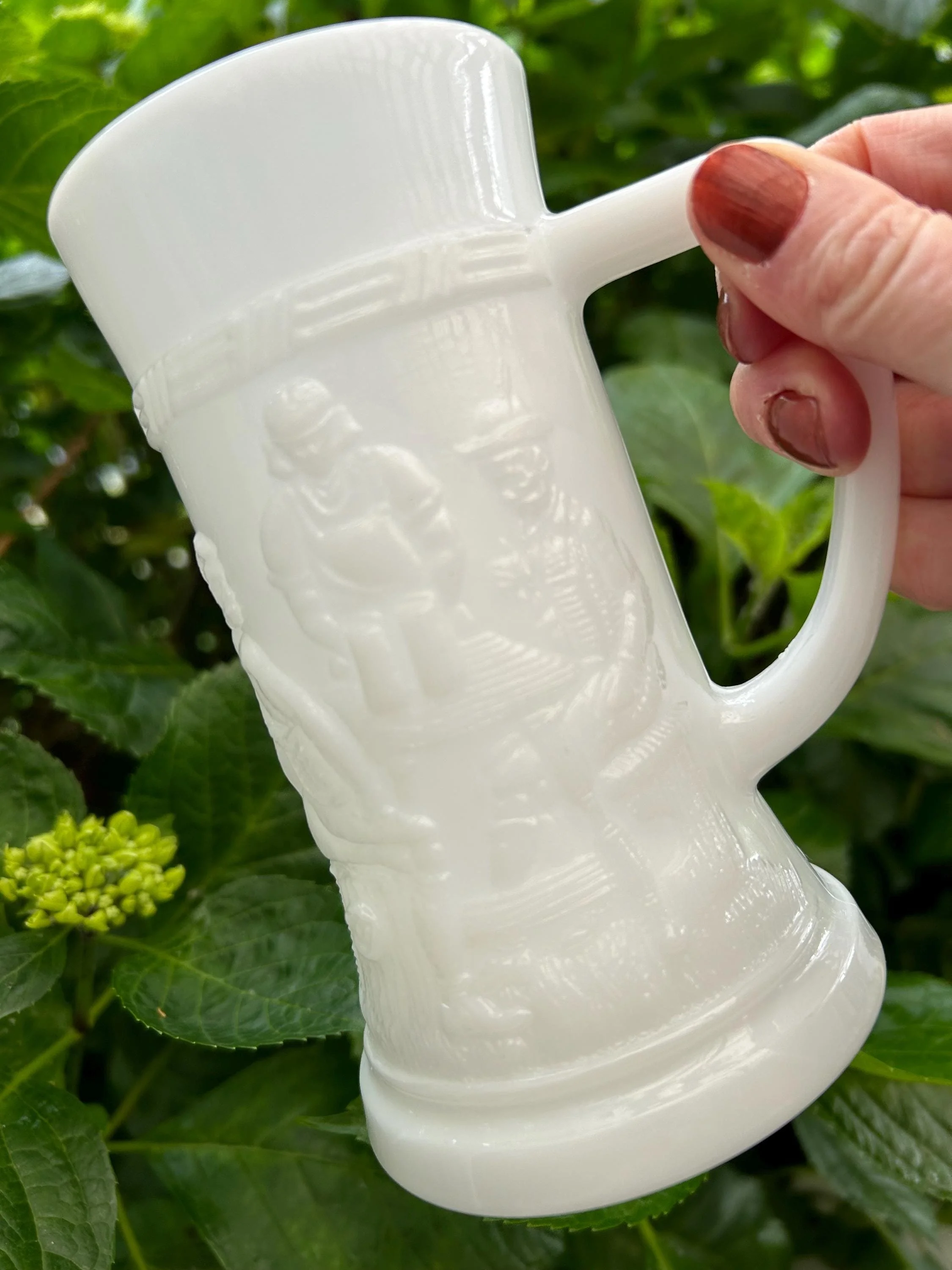 Side profile showing flared rim and detailed embossed figures