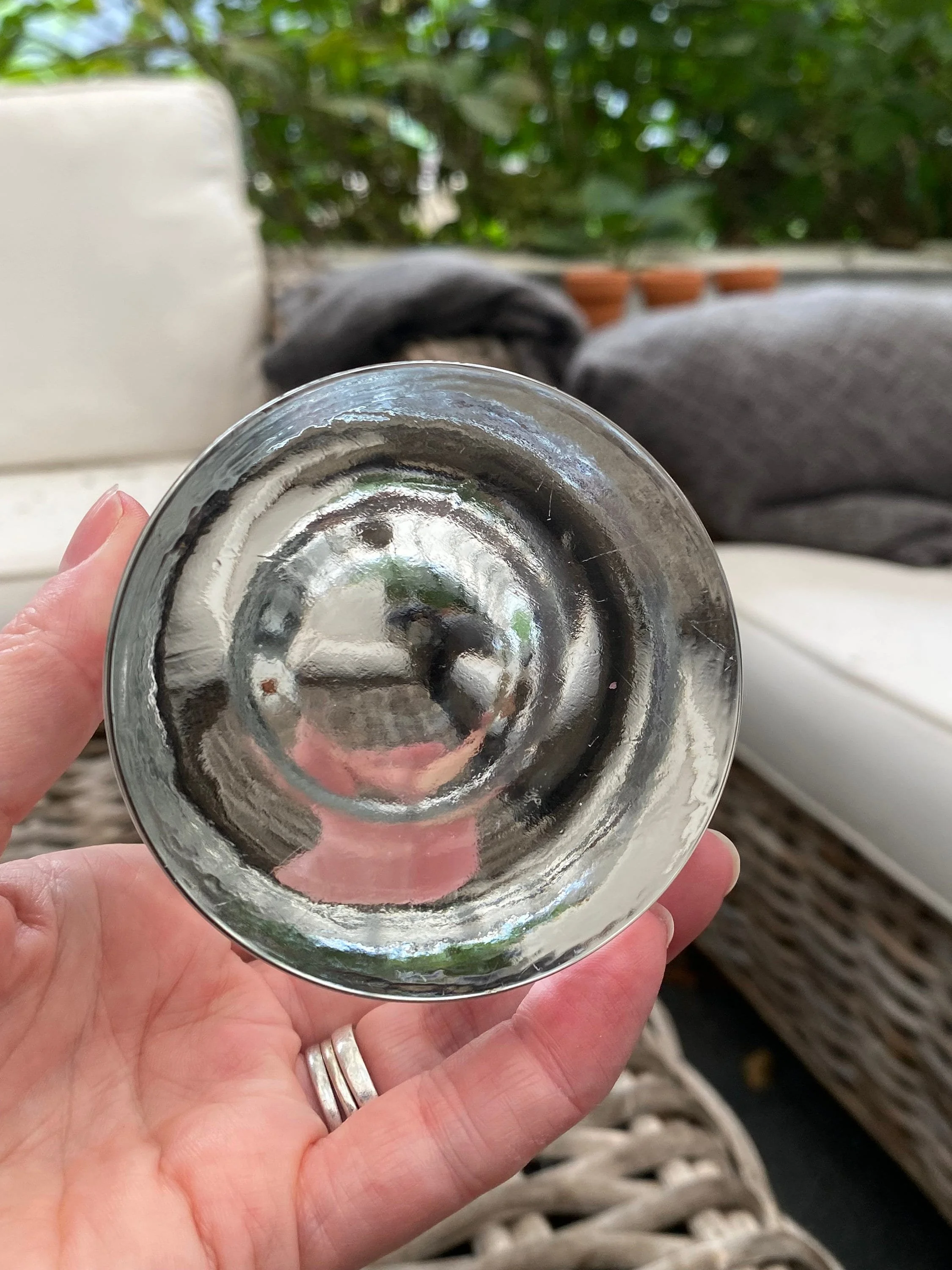 Underside of the glass holder shown in hand, displaying the polished base and thickness of the glass