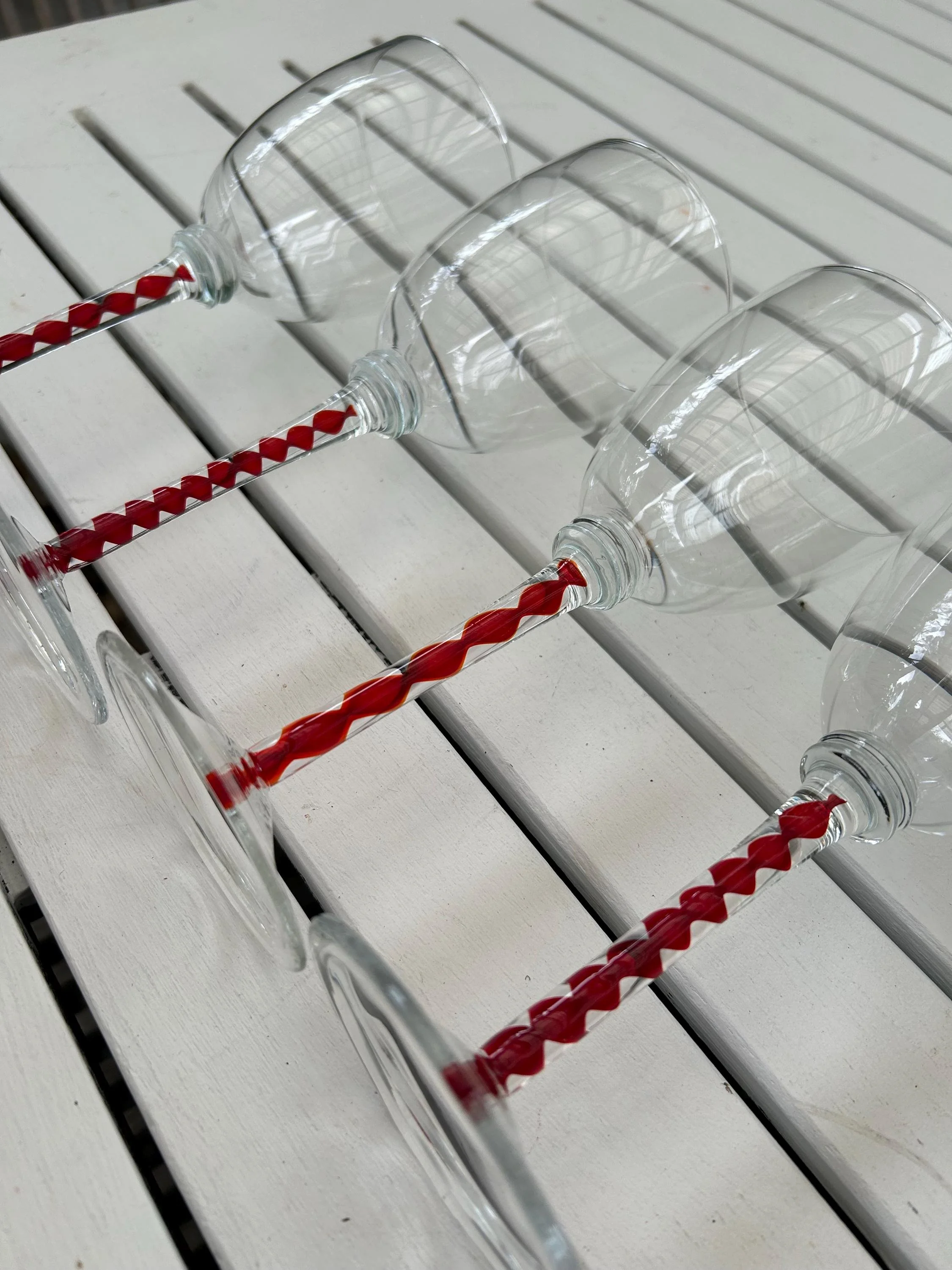 Top-down angled view of glasses laid down to show red ribbon stems