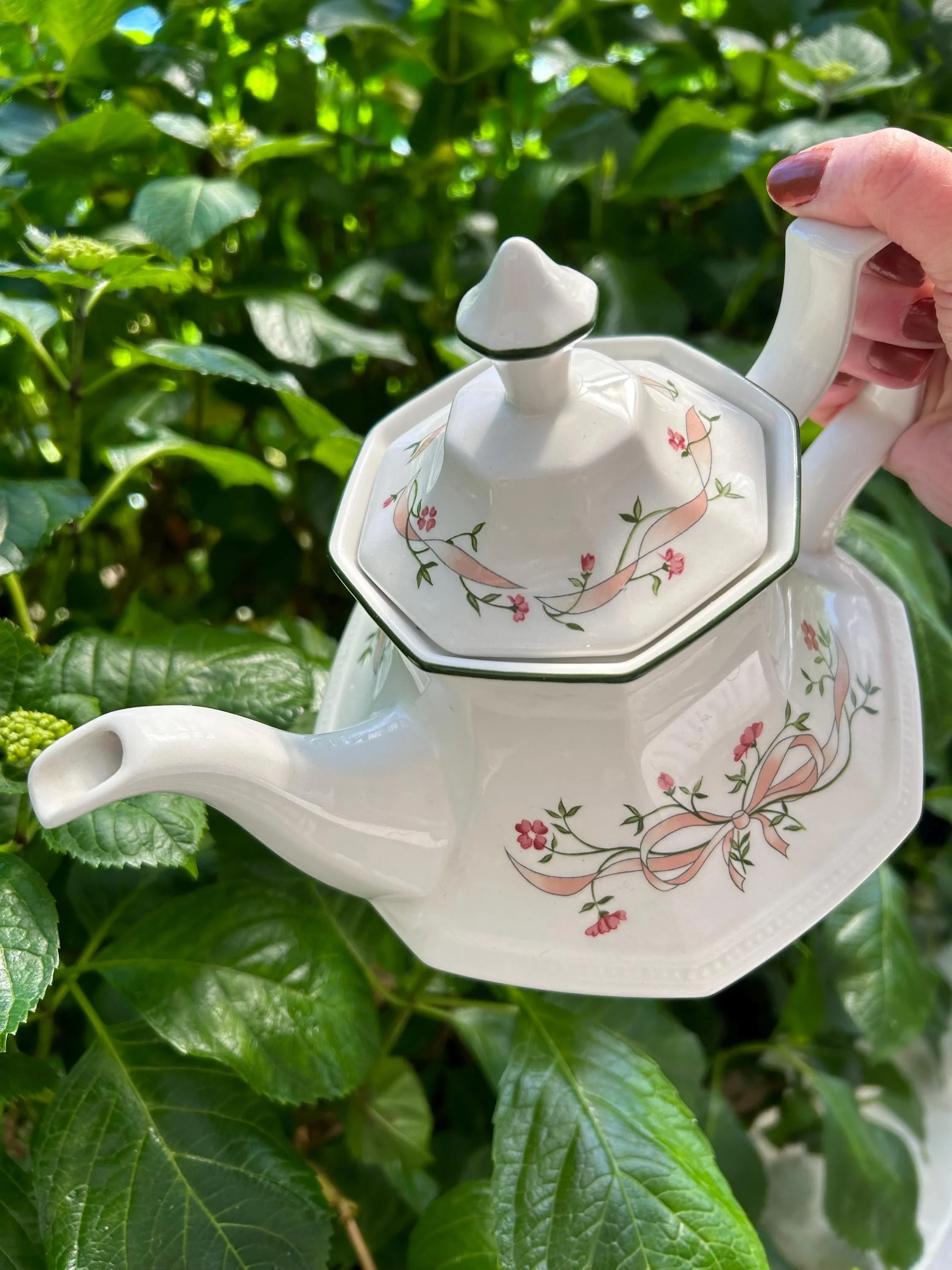 Close-up of lid finial and green-rimmed floral pattern