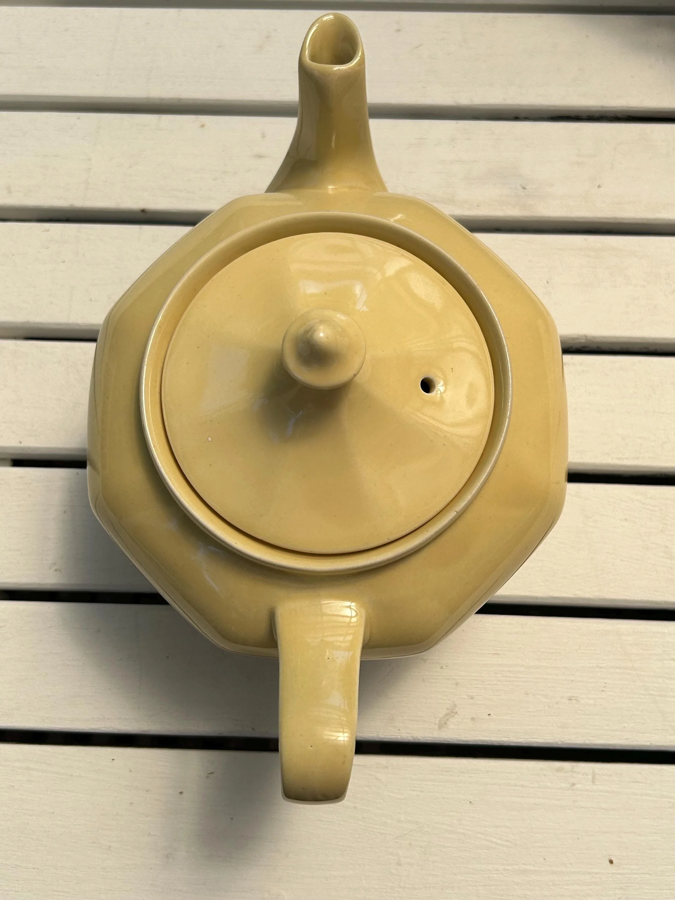 Overhead view of teapot showing spout, finial lid, and yellow glaze