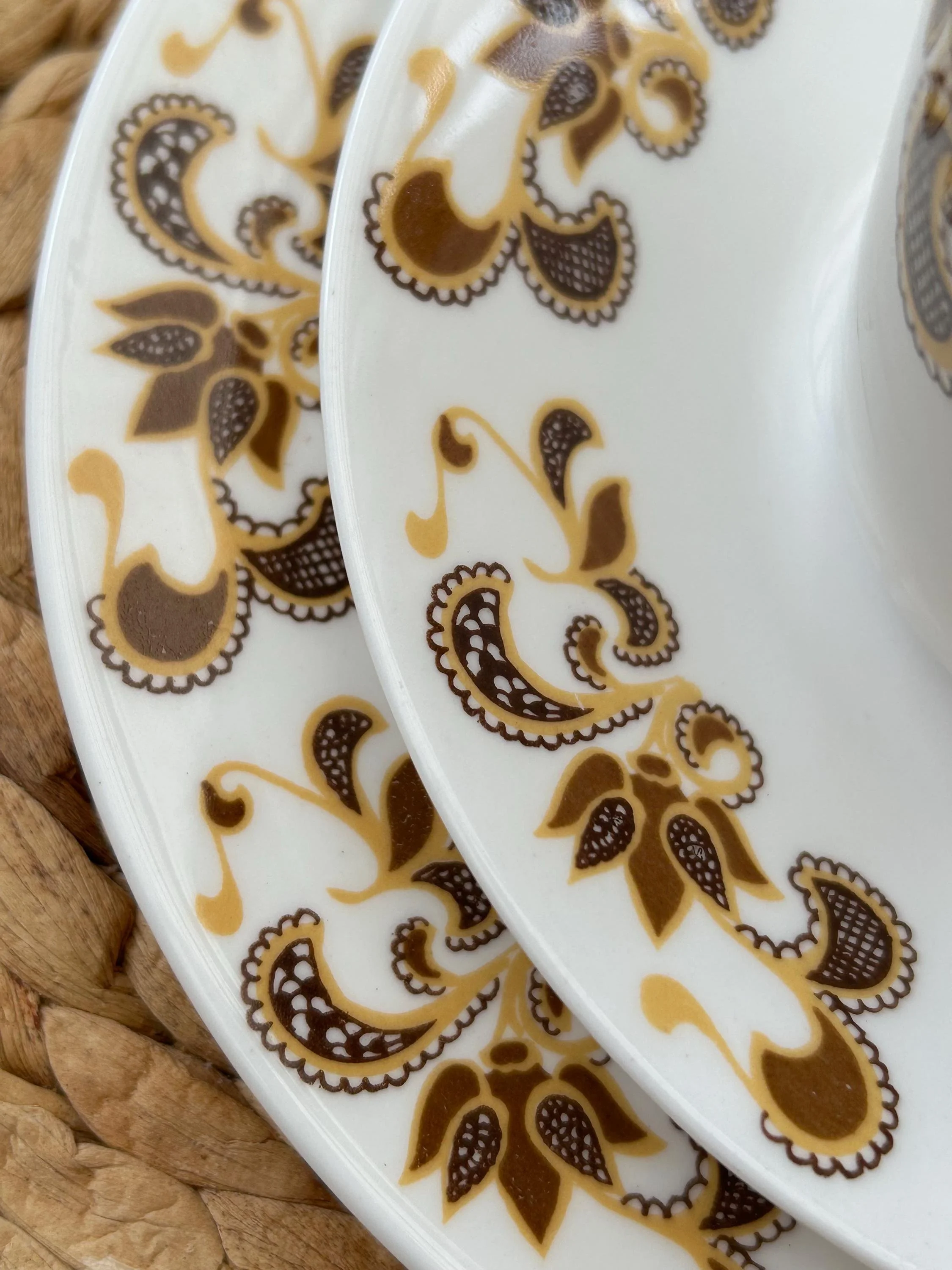 Detail of side plate and saucer showing printed abstract florals and scalloped edge