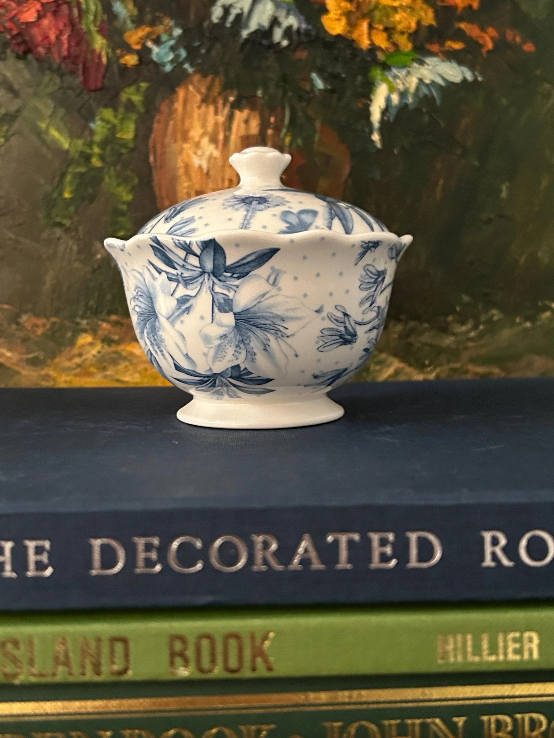 Portmeirion Botanic Blue sugar bowl with lid against floral painting backdrop