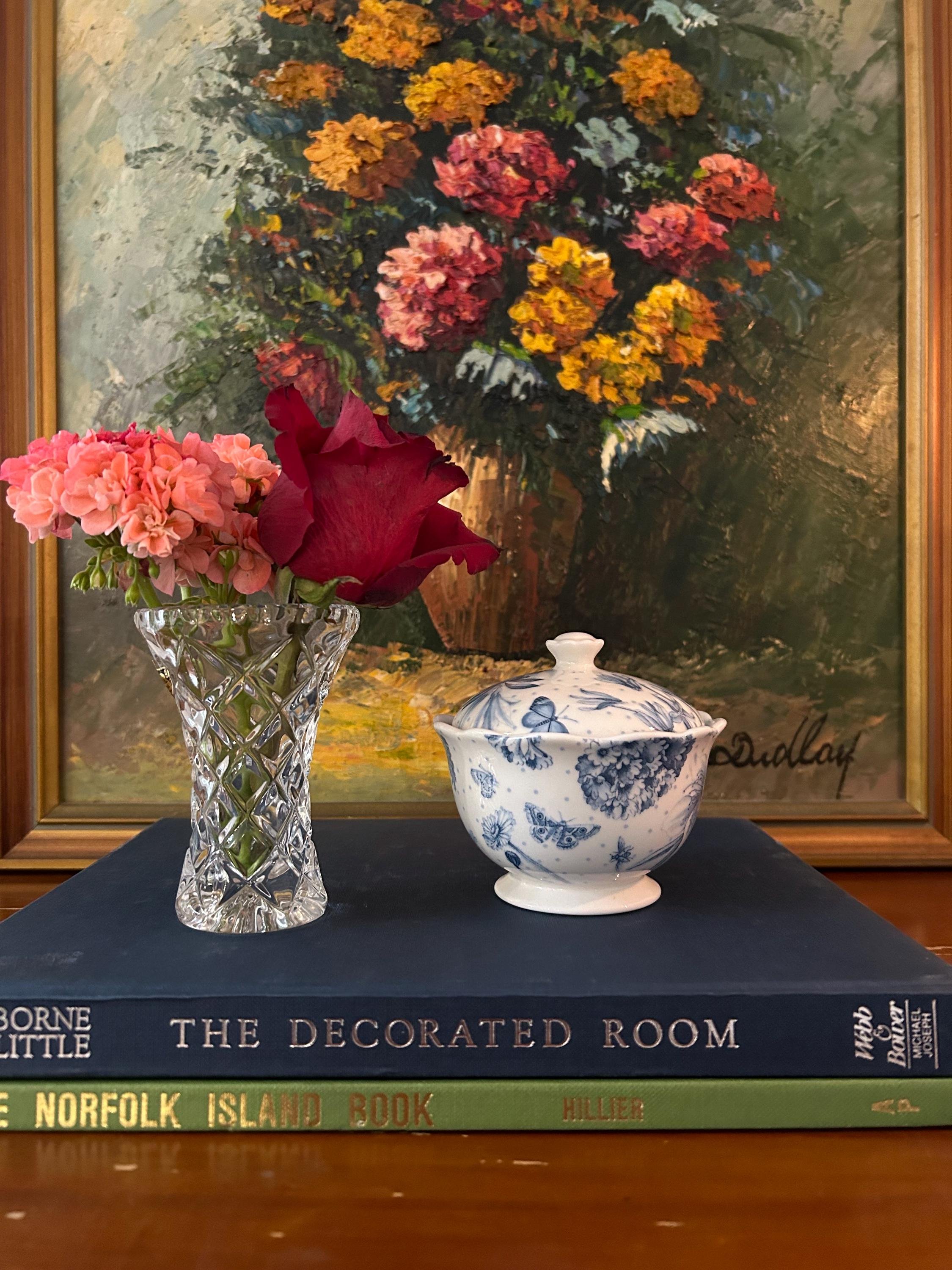 Sugar bowl styled next to flowers and vintage artwork