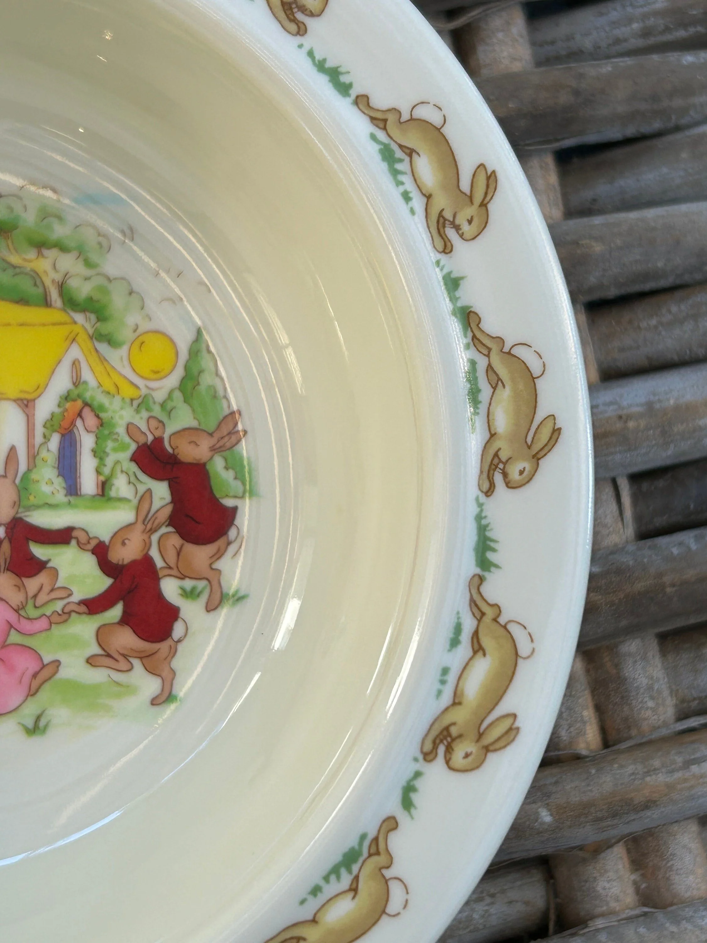 Angled close-up of bowl interior and rim with repeating Bunnykins rabbit border and part of the dancing bunny scene