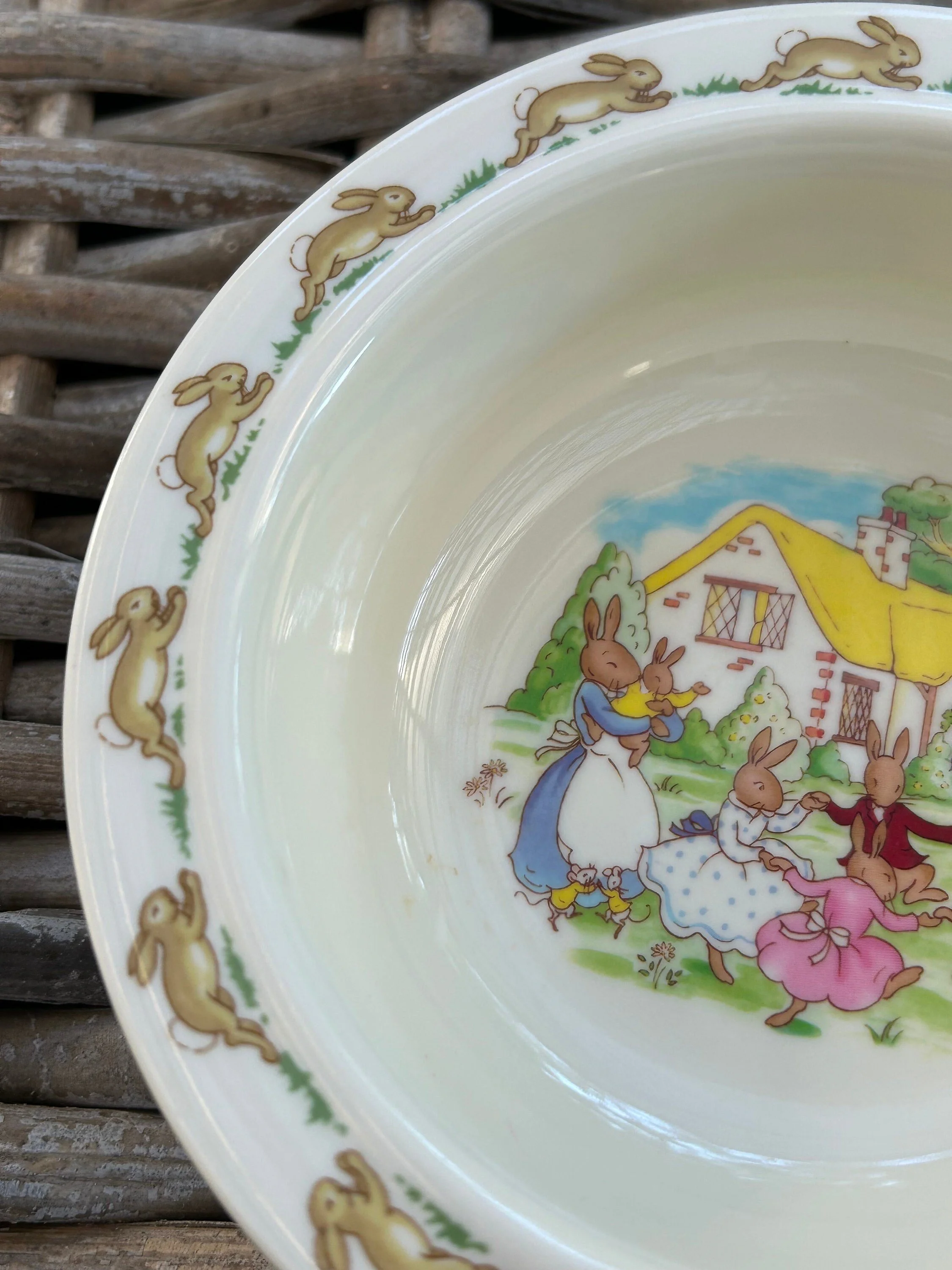 Oblique view into Royal Doulton Bunnykins bowl showing full interior scene and decorative rabbit border around the rim