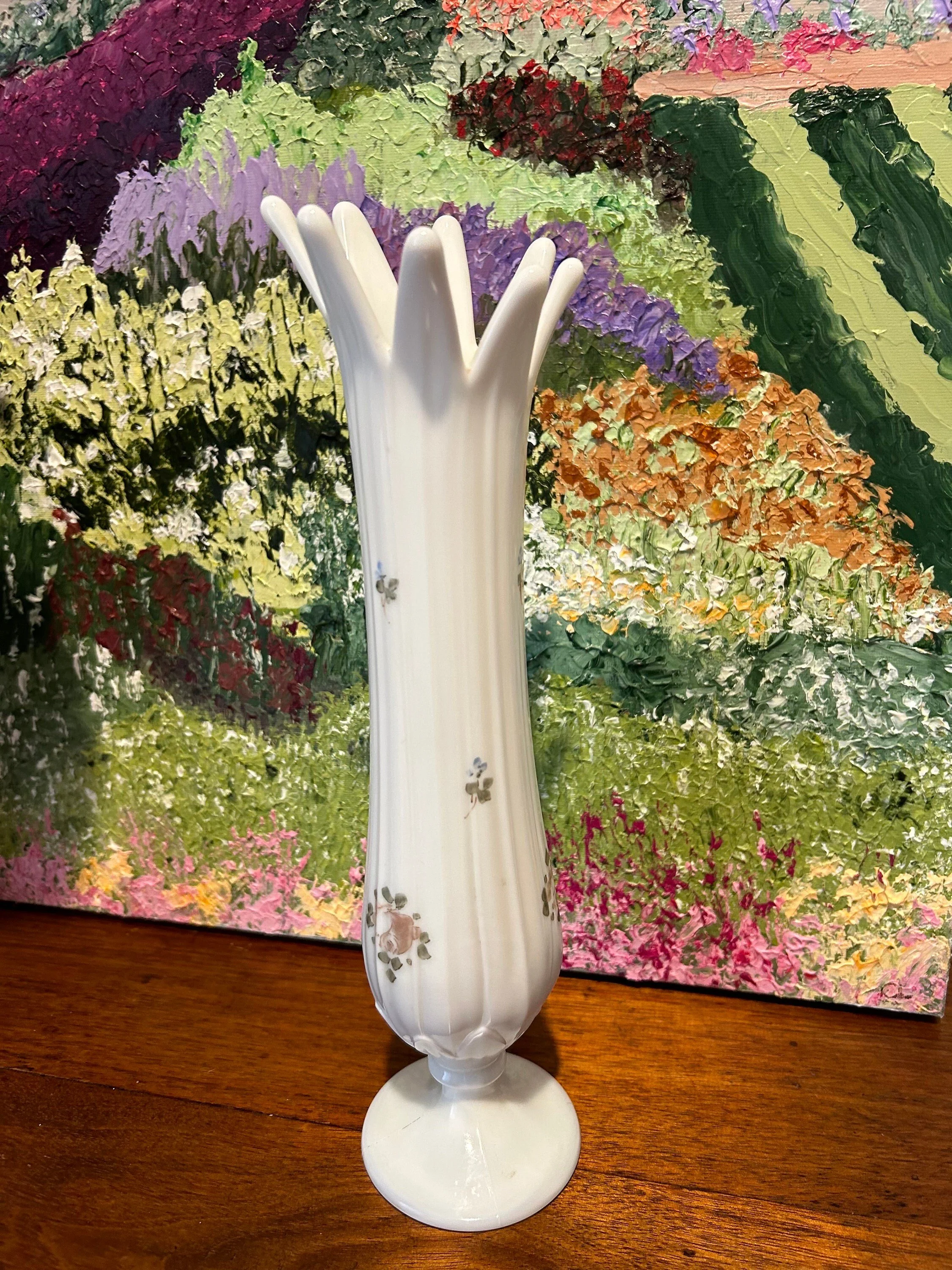 Front-facing vase styled in front of impressionist floral backdrop