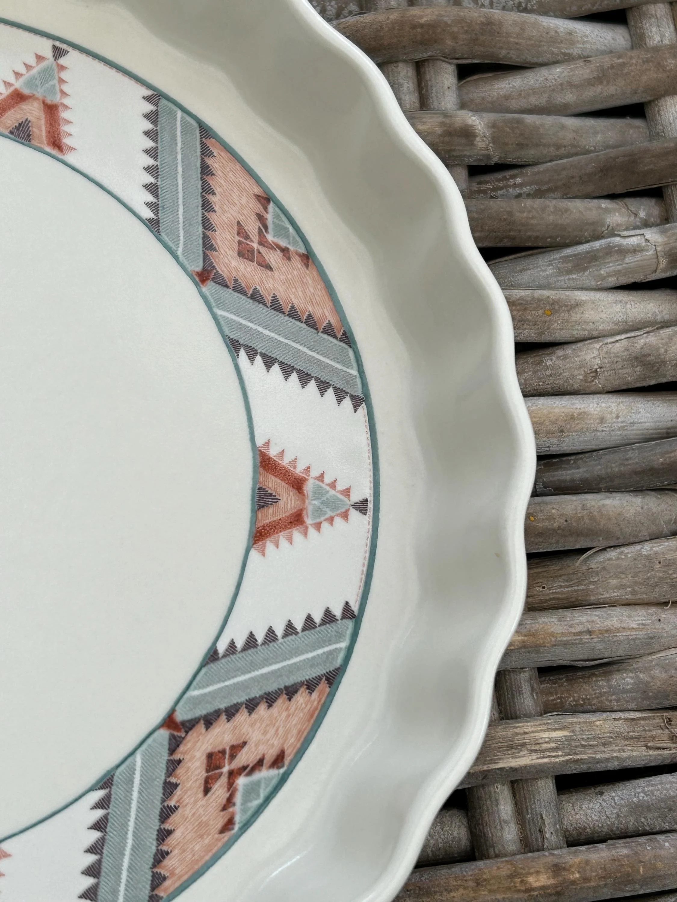Close-up of patterned rim – terracotta, grey, and teal motif detail