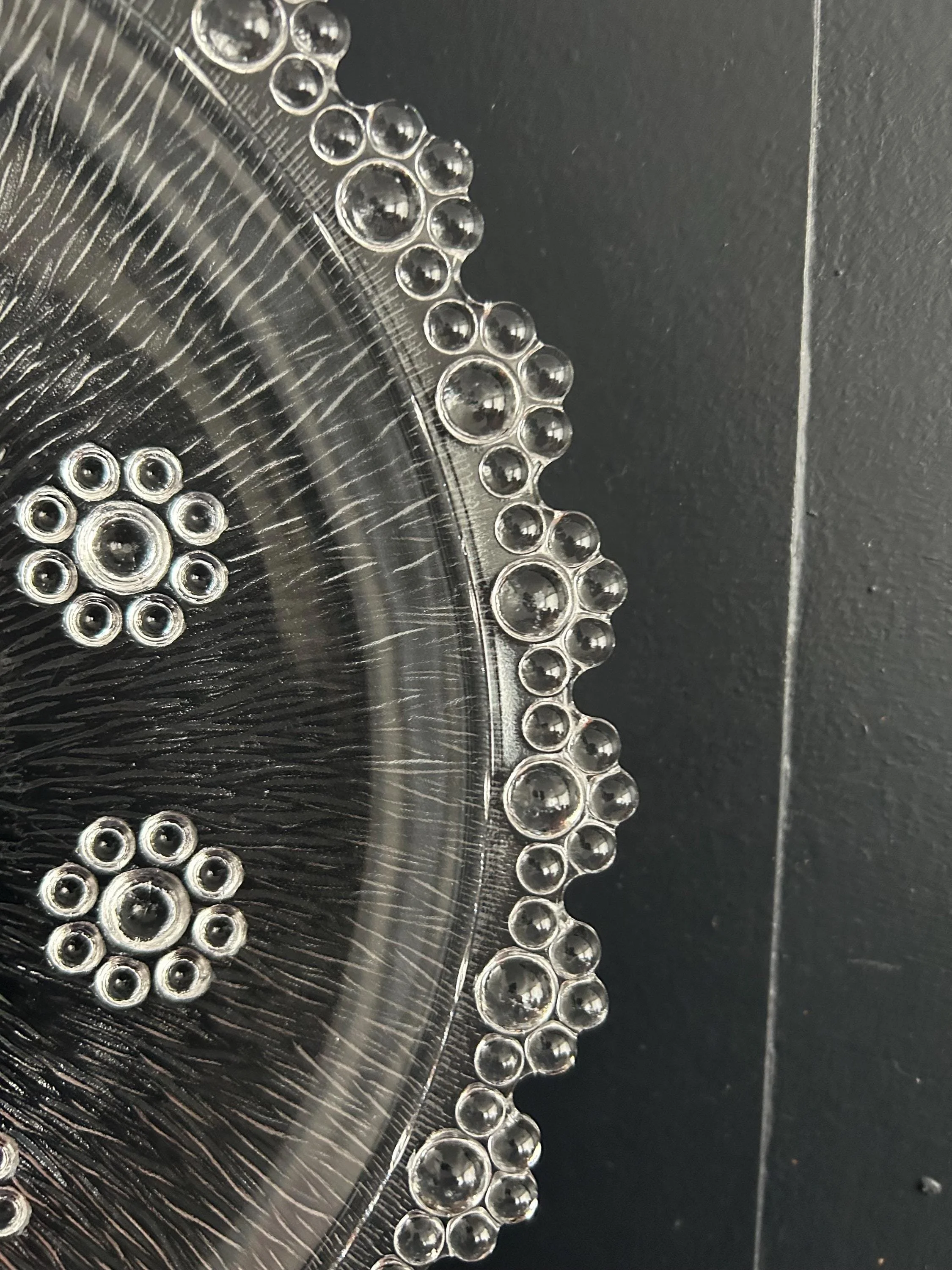 Edge macro showing cluster of glass bubbles along the rim