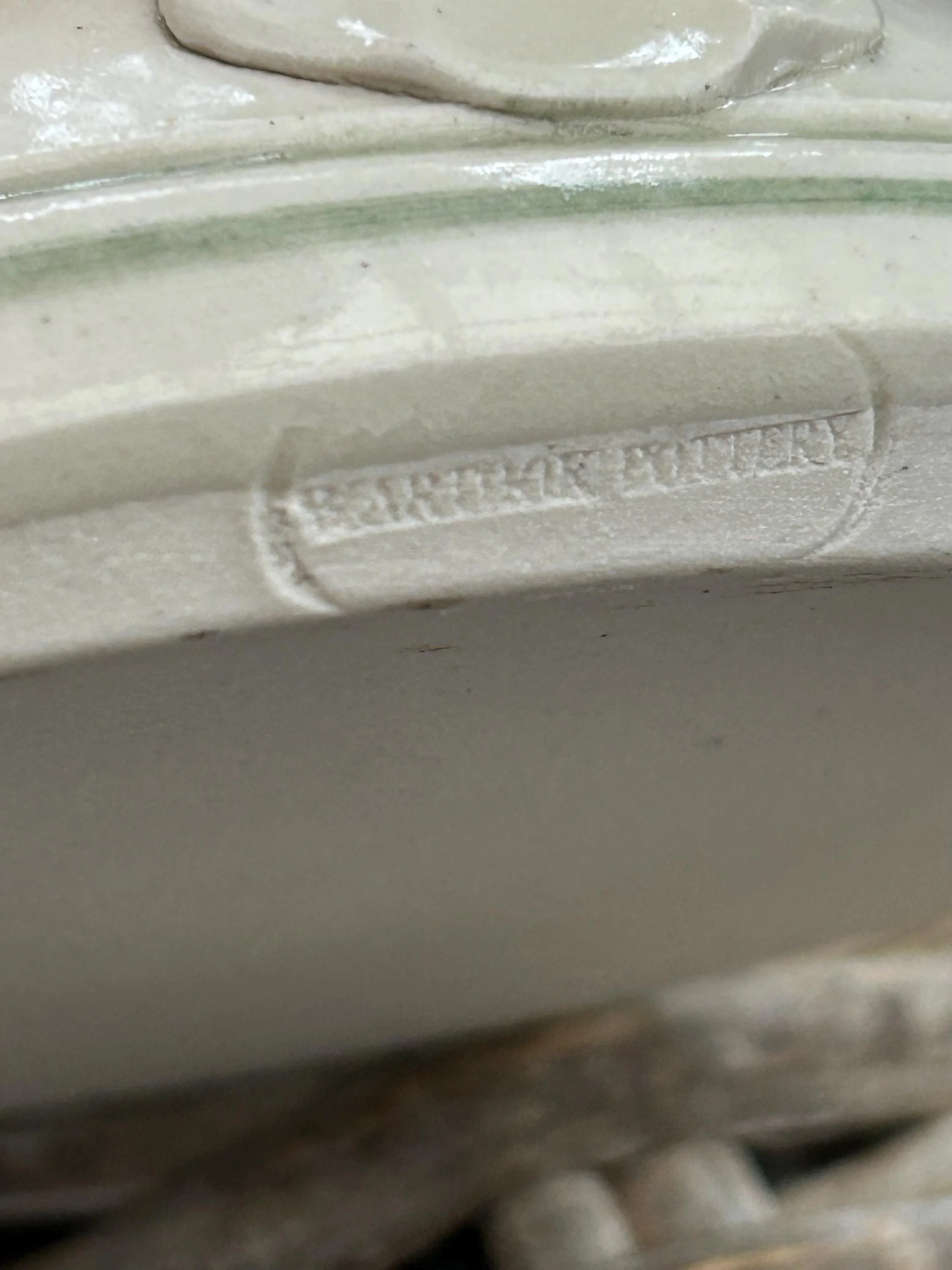 Close-up of impressed maker’s mark reading “Earthware Pottery”