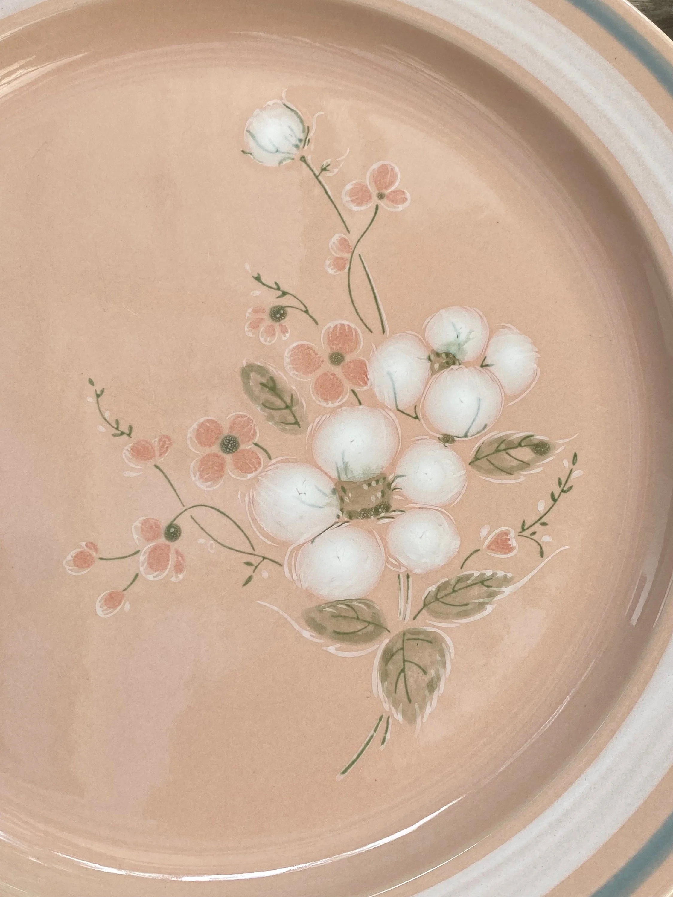 Close-up of a large dinner plate with white blossom detail