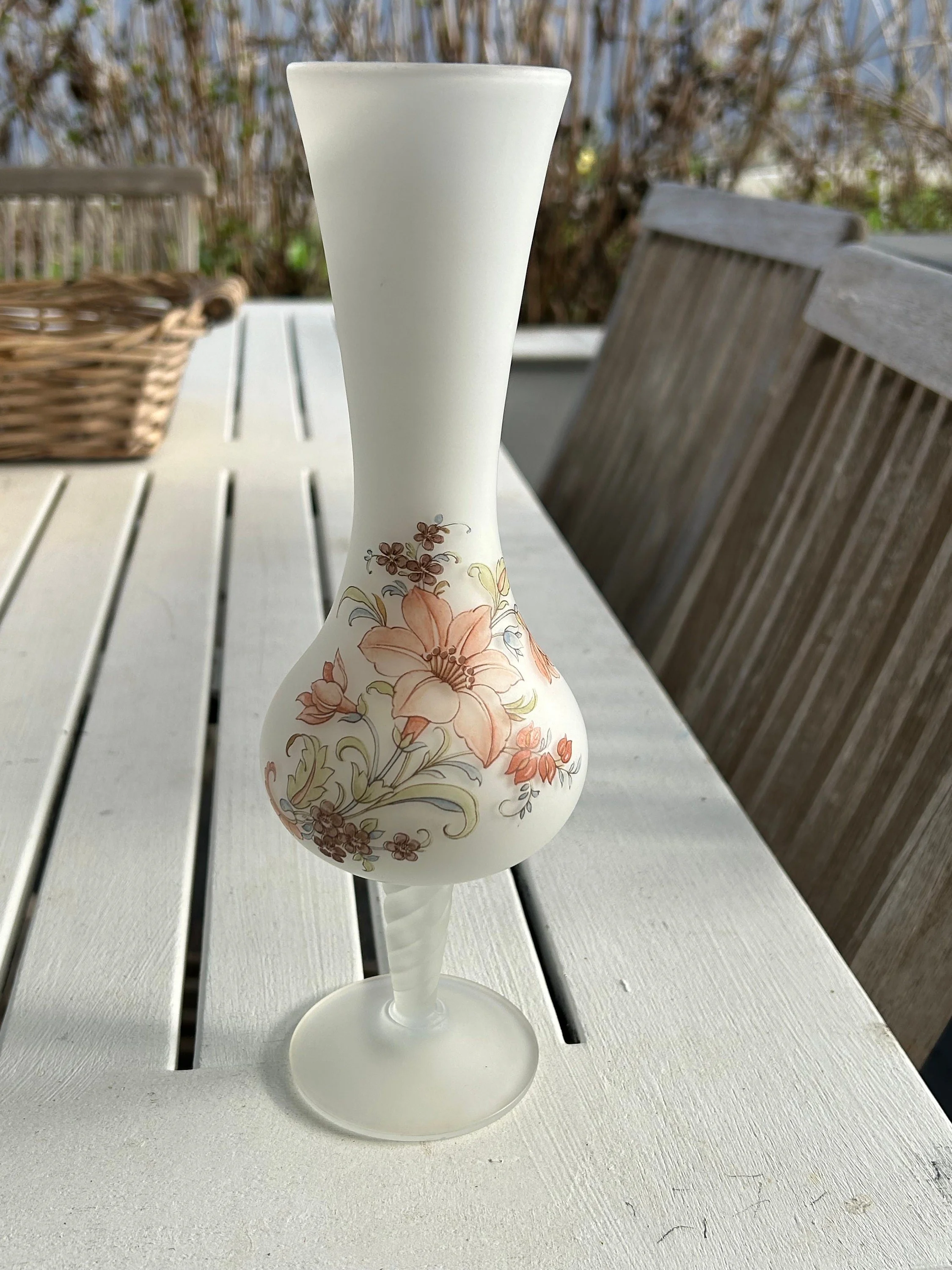 Full view of frosted glass bud vase on white outdoor table