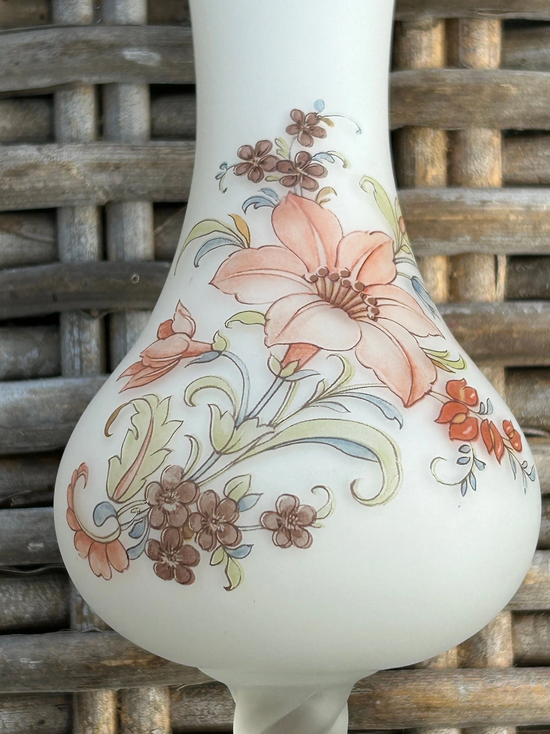 Close-up of handpainted floral motif in soft peach and sage tones