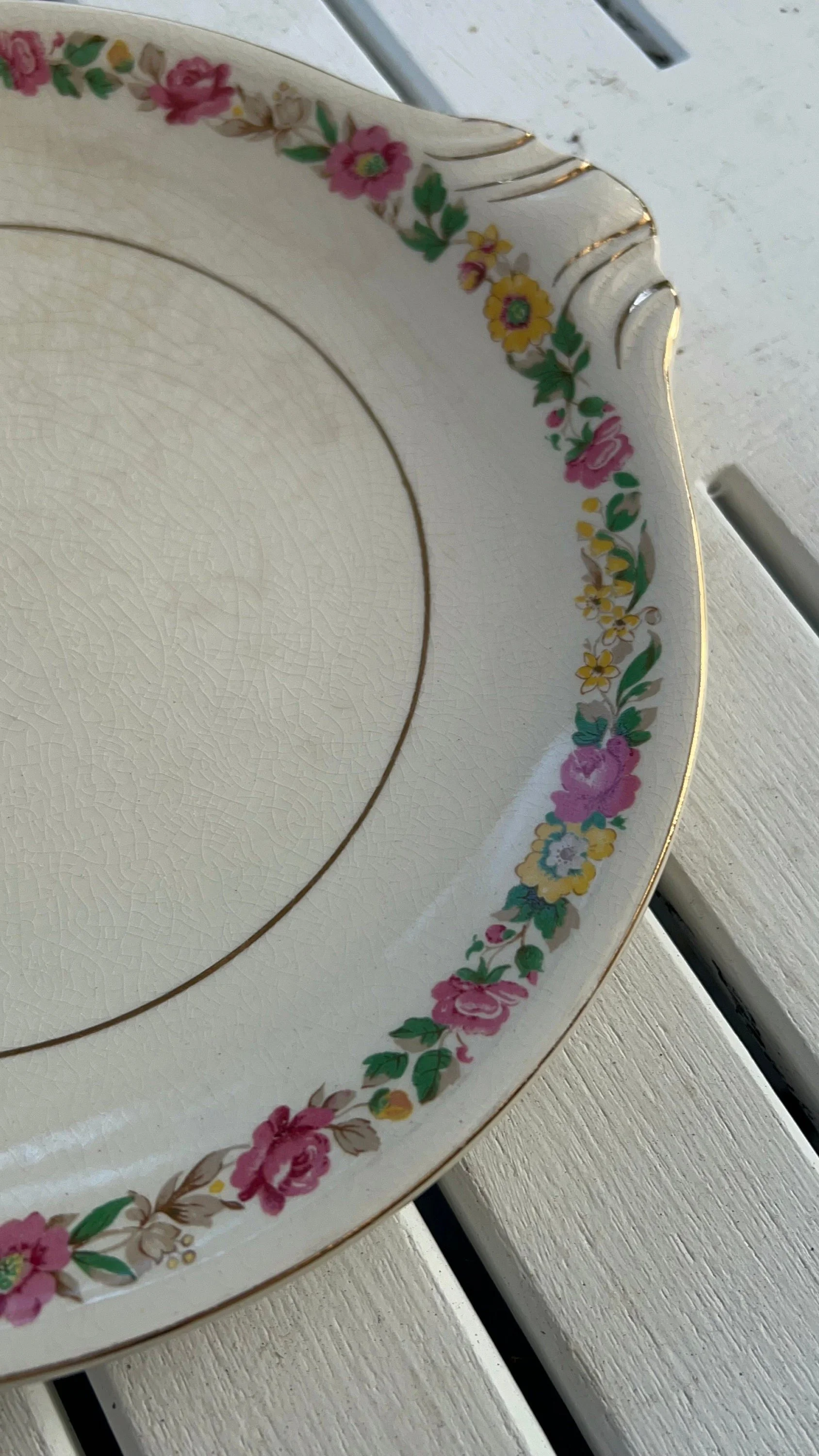 Detailed close-up of floral garland and gold trim on plate edge