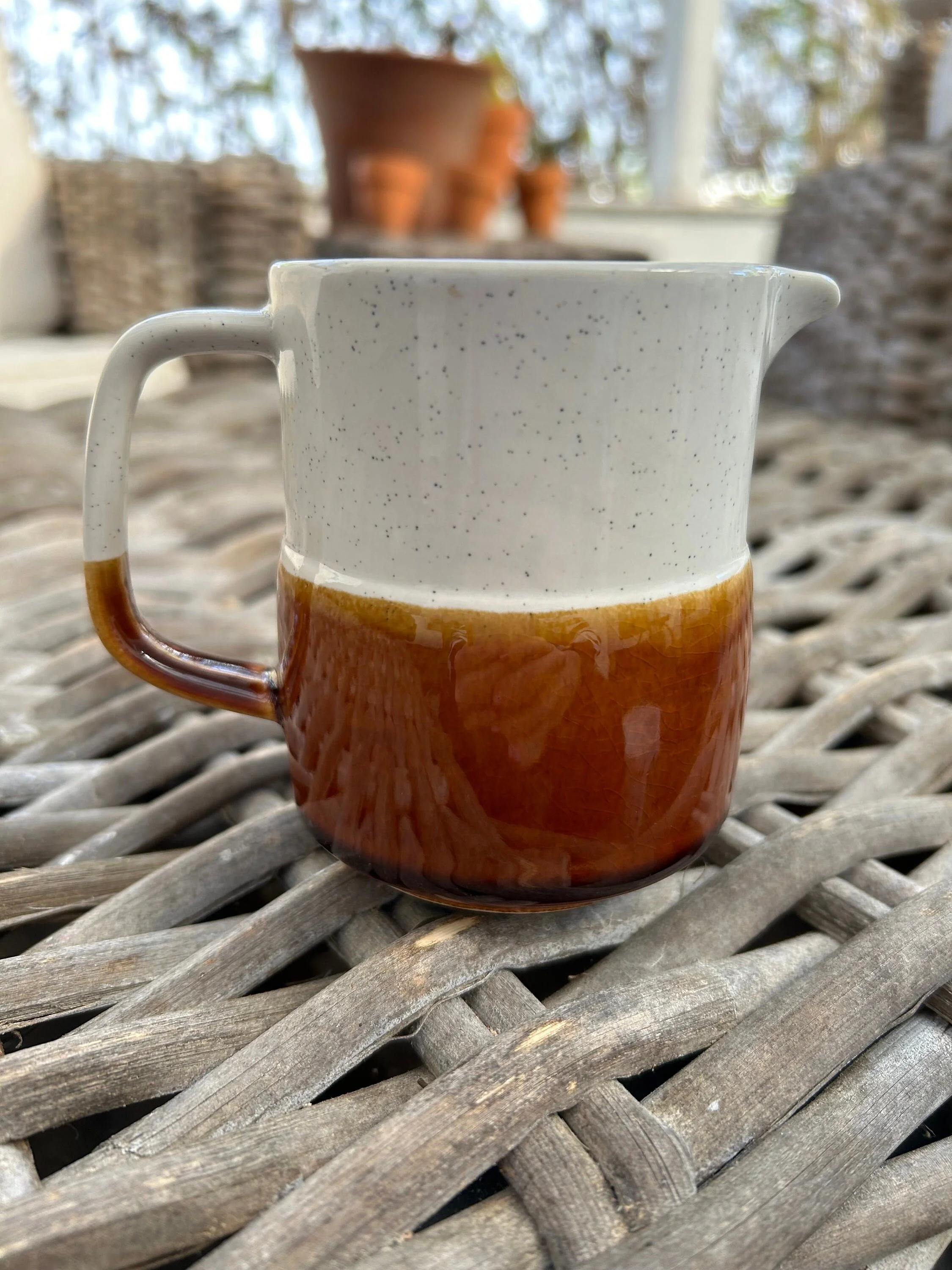 Front view of the creamer jug showing the pouring spout and rich brown lower glaze