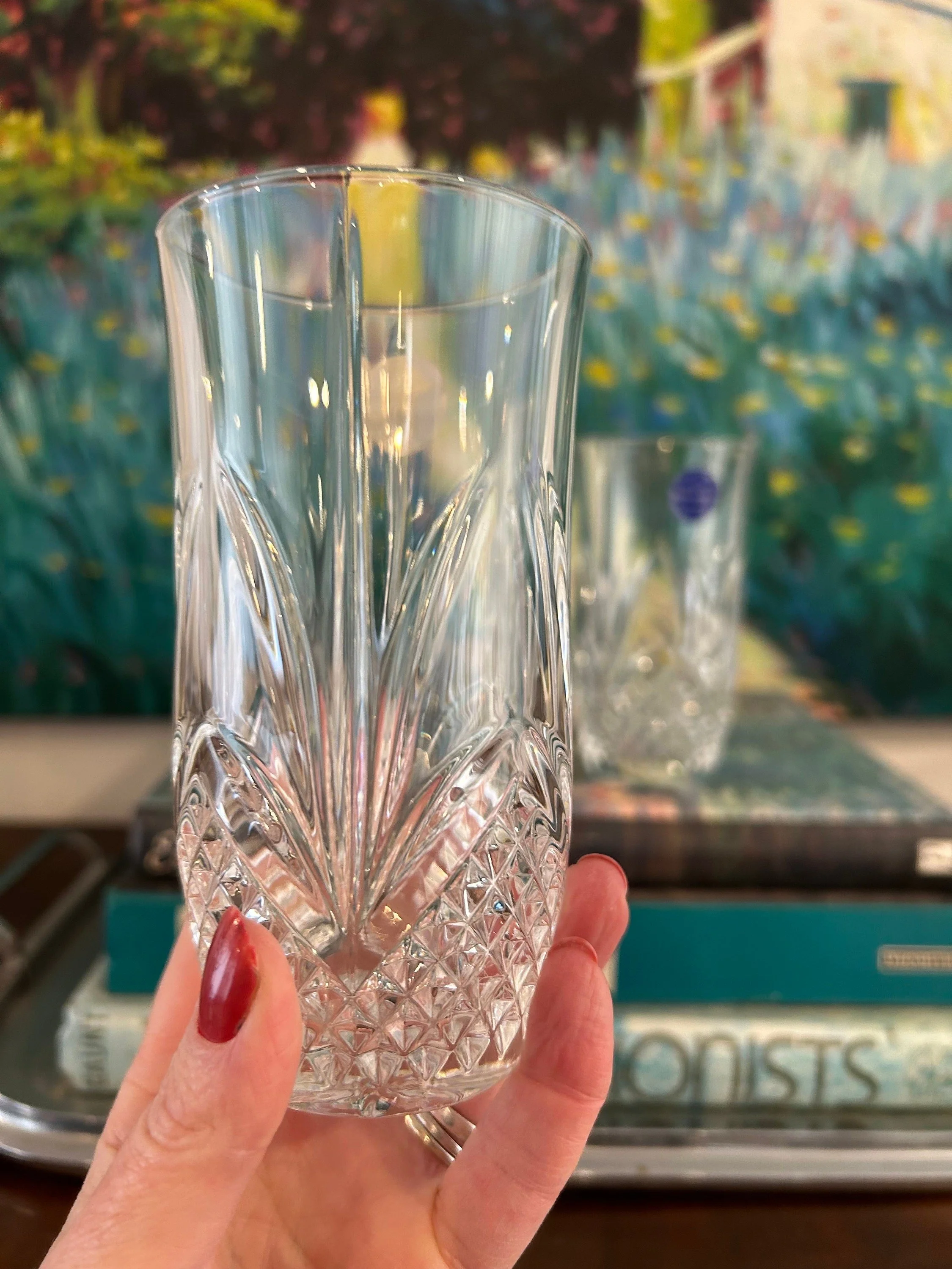 Single tumbler held against Monet-style floral painting background