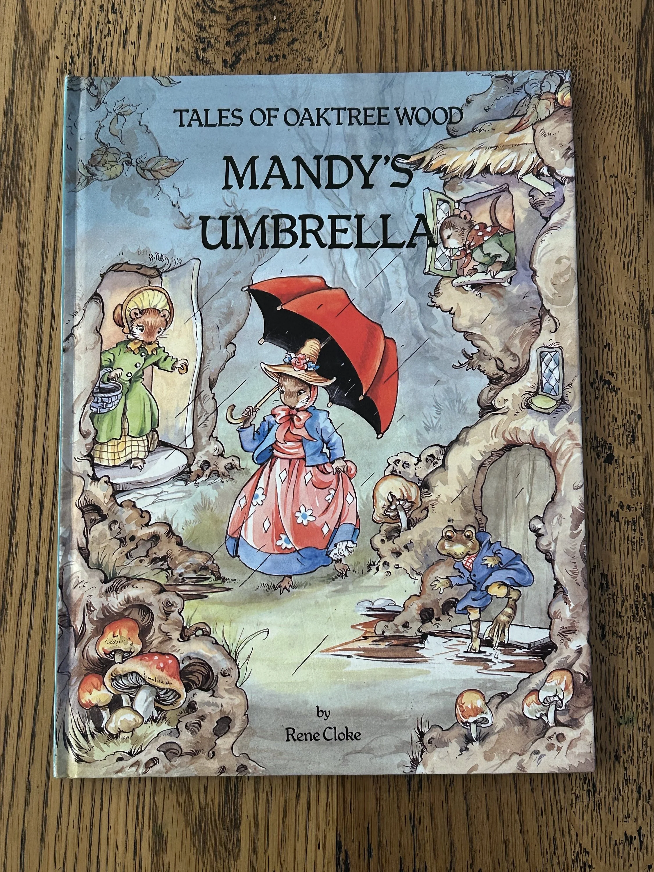 Cover of Mandy’s Umbrella showing Mandy the Woodmouse with red umbrella in a woodland setting