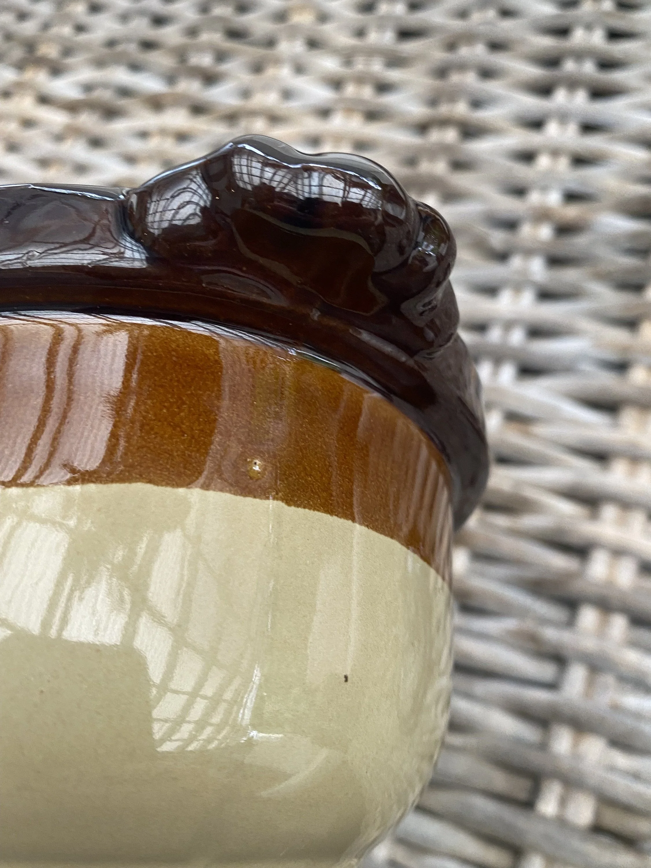 Detailed side view of the handle and upper brown glazed rim on the ceramic pot