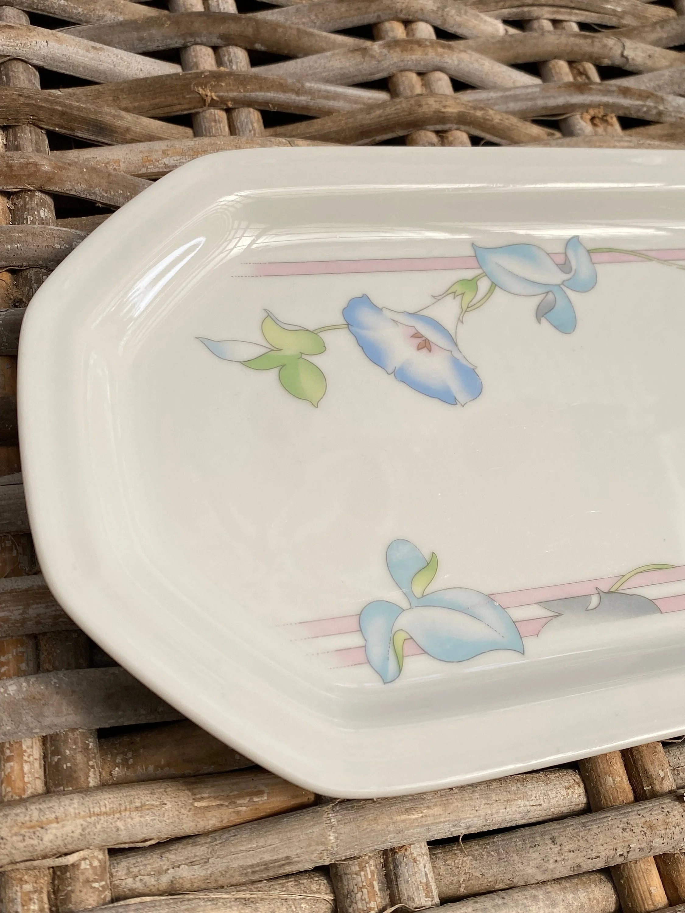 Angled close-up of the platter rim and morning glory motif on the upper corner