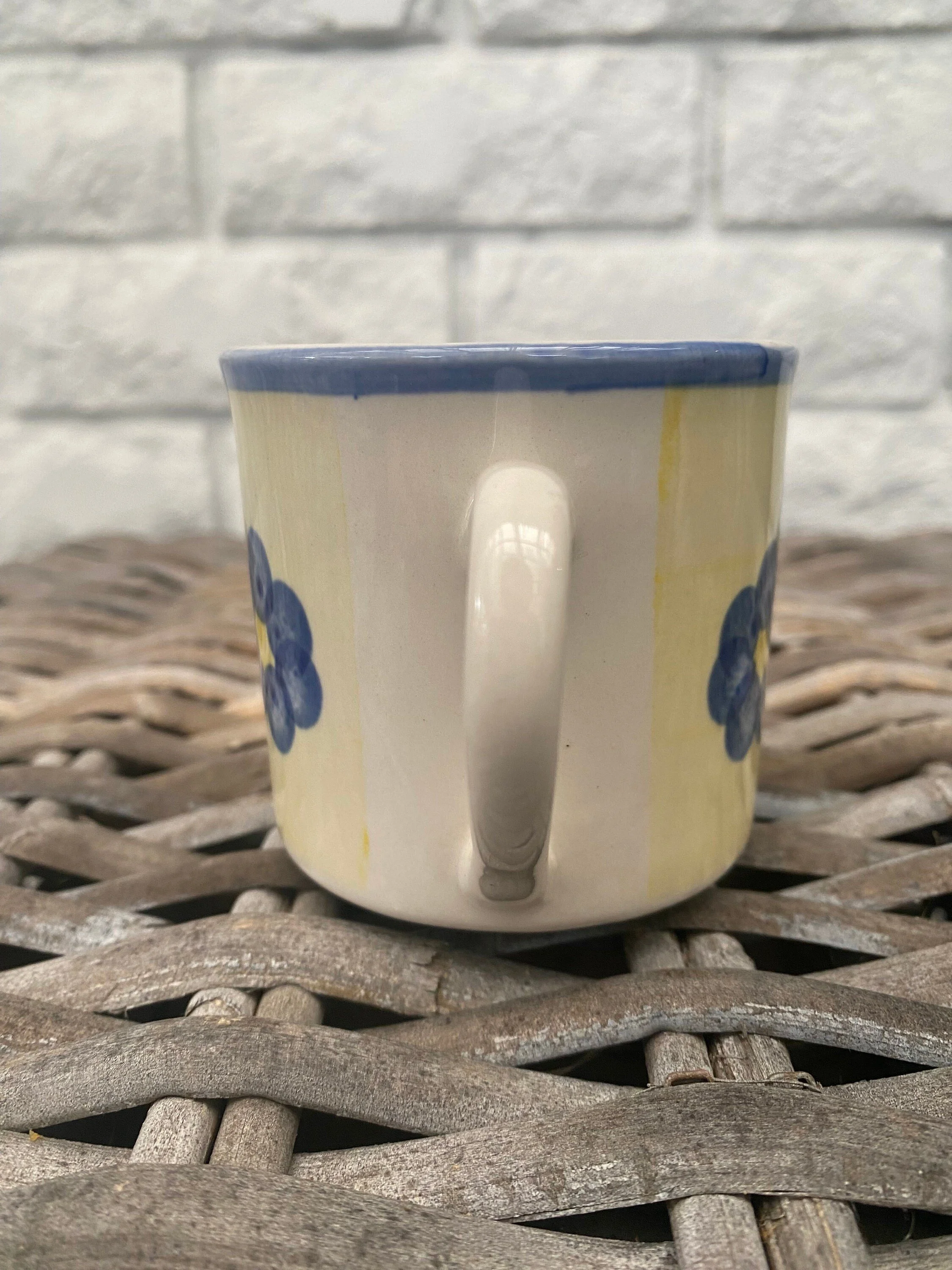 Rear view of vintage floral stoneware mug showing handle and wraparound blue flower design