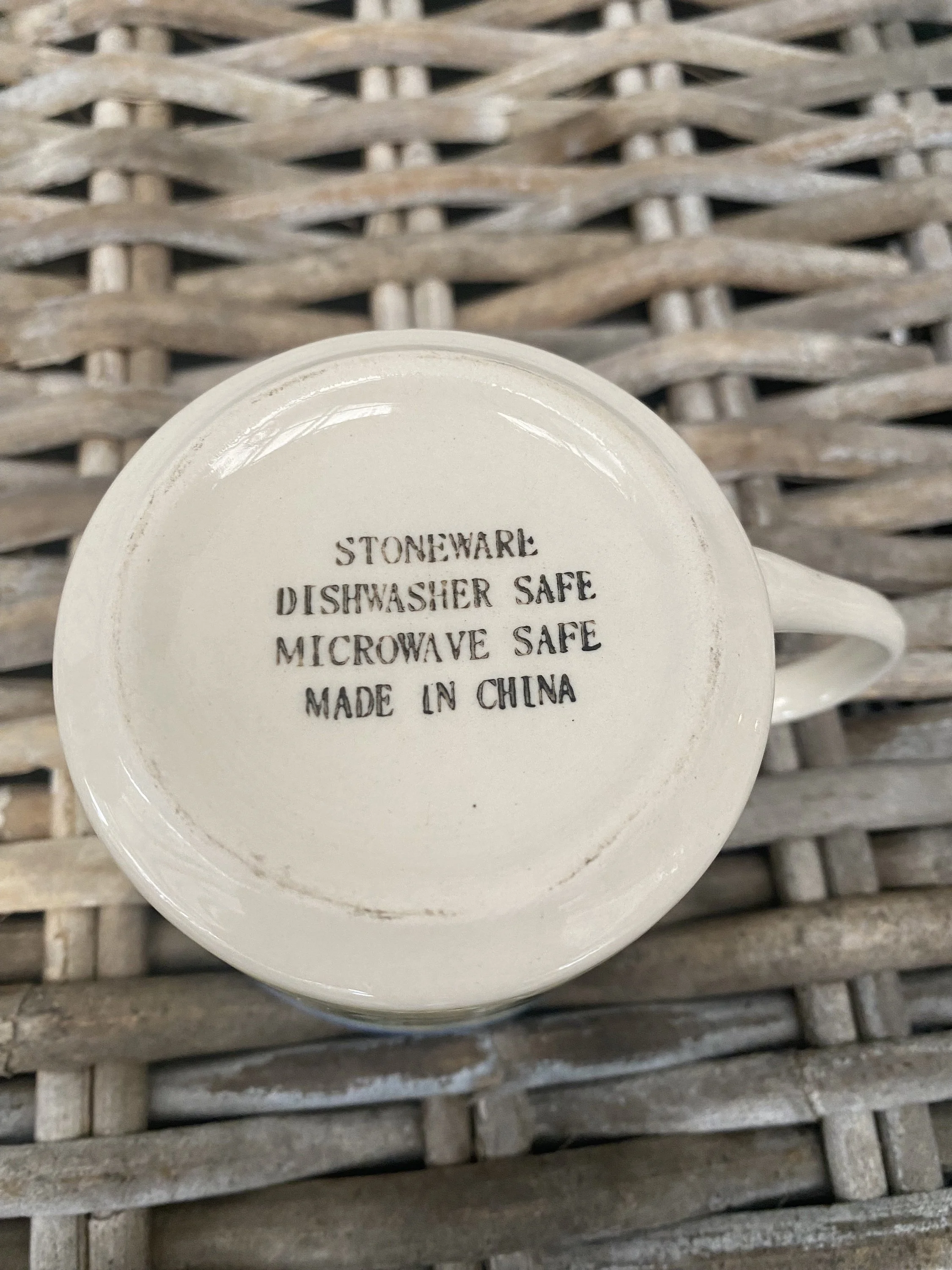 Underside of vintage stoneware mug showing maker’s stamp with dishwasher safe, microwave safe, and made in China details