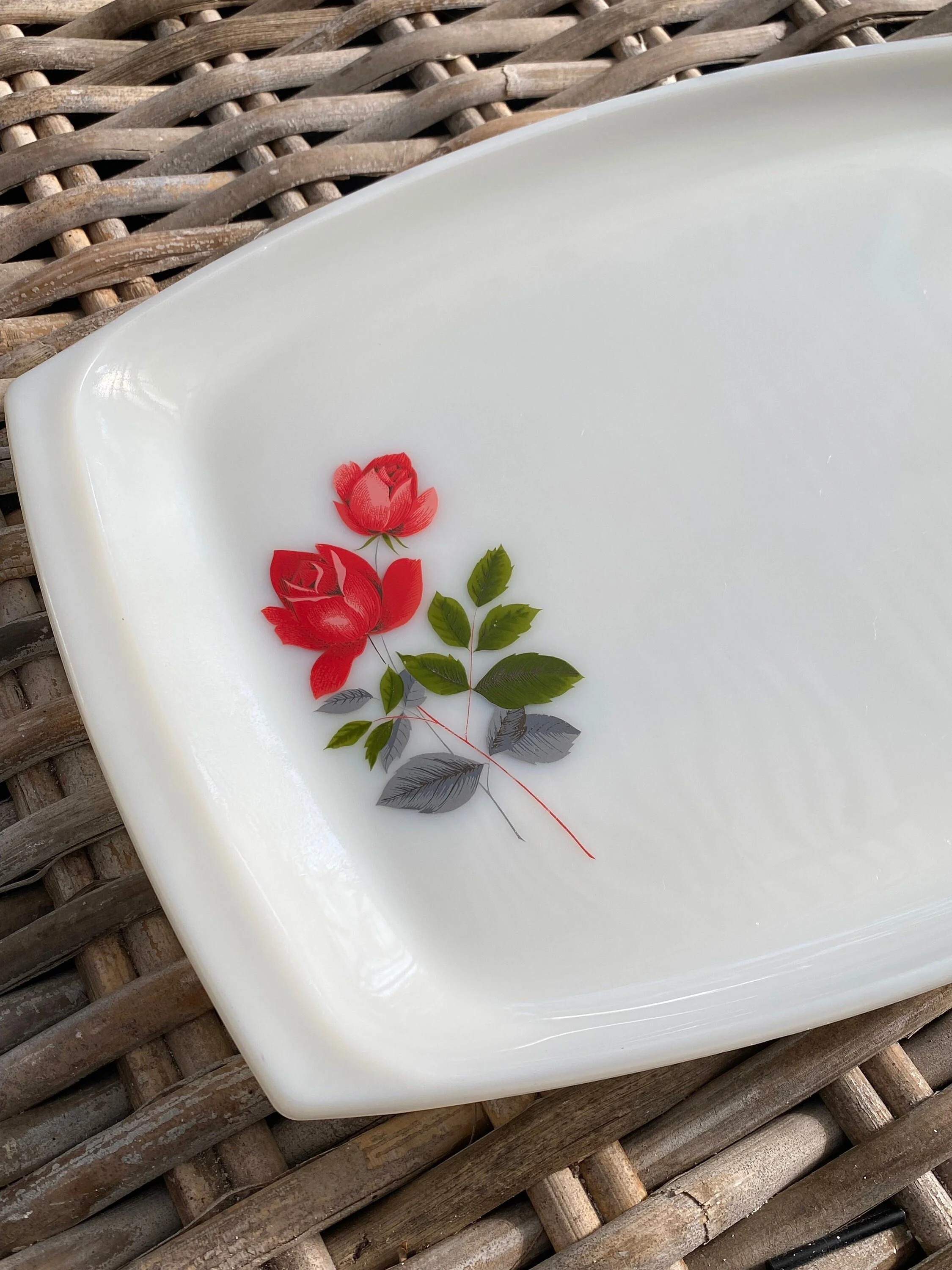 Close-up of red rose motif and green leaves on one end