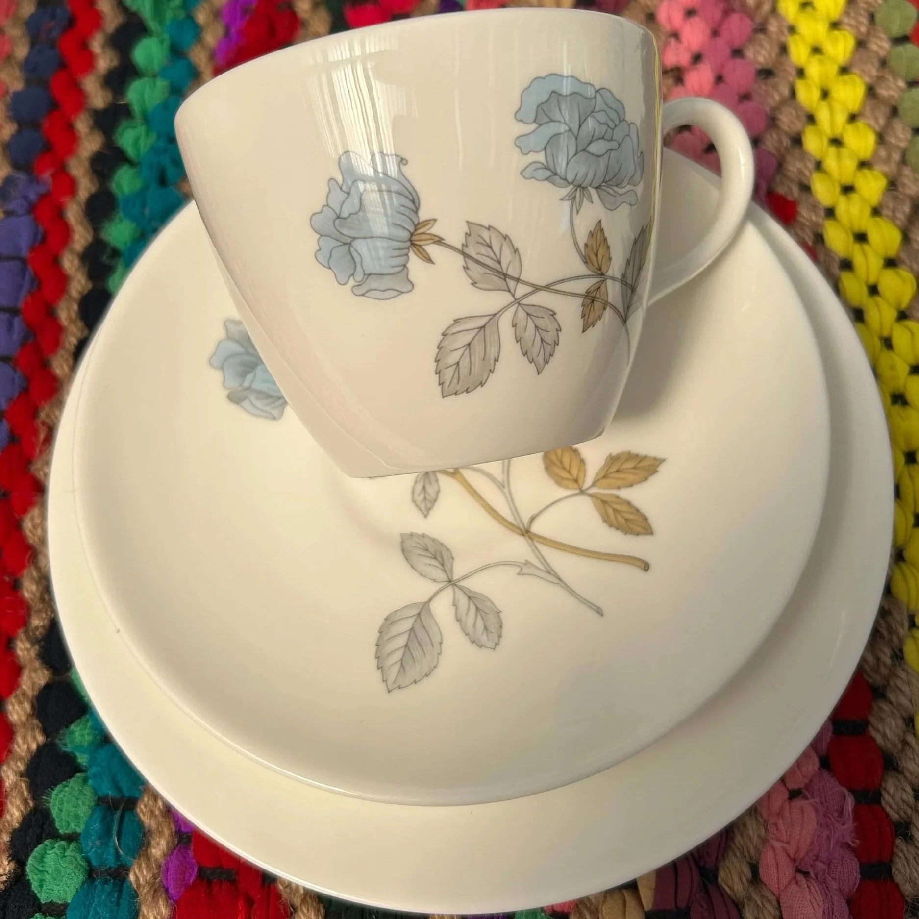Teacup resting on saucer and plate, highlighting how the floral motifs coordinate across the set