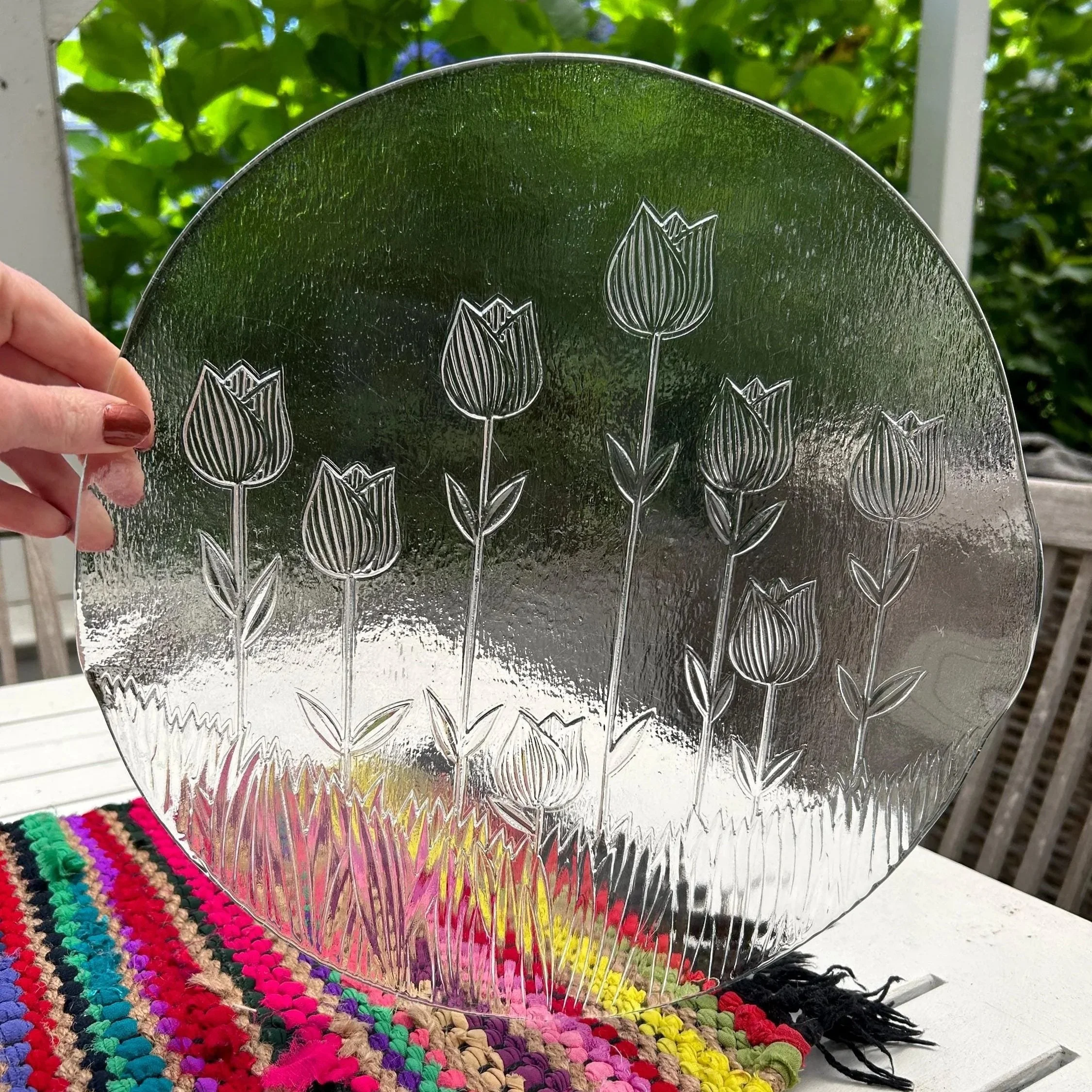 Round IVV Italian glass platter featuring etched tulip design held against colourful fabric.