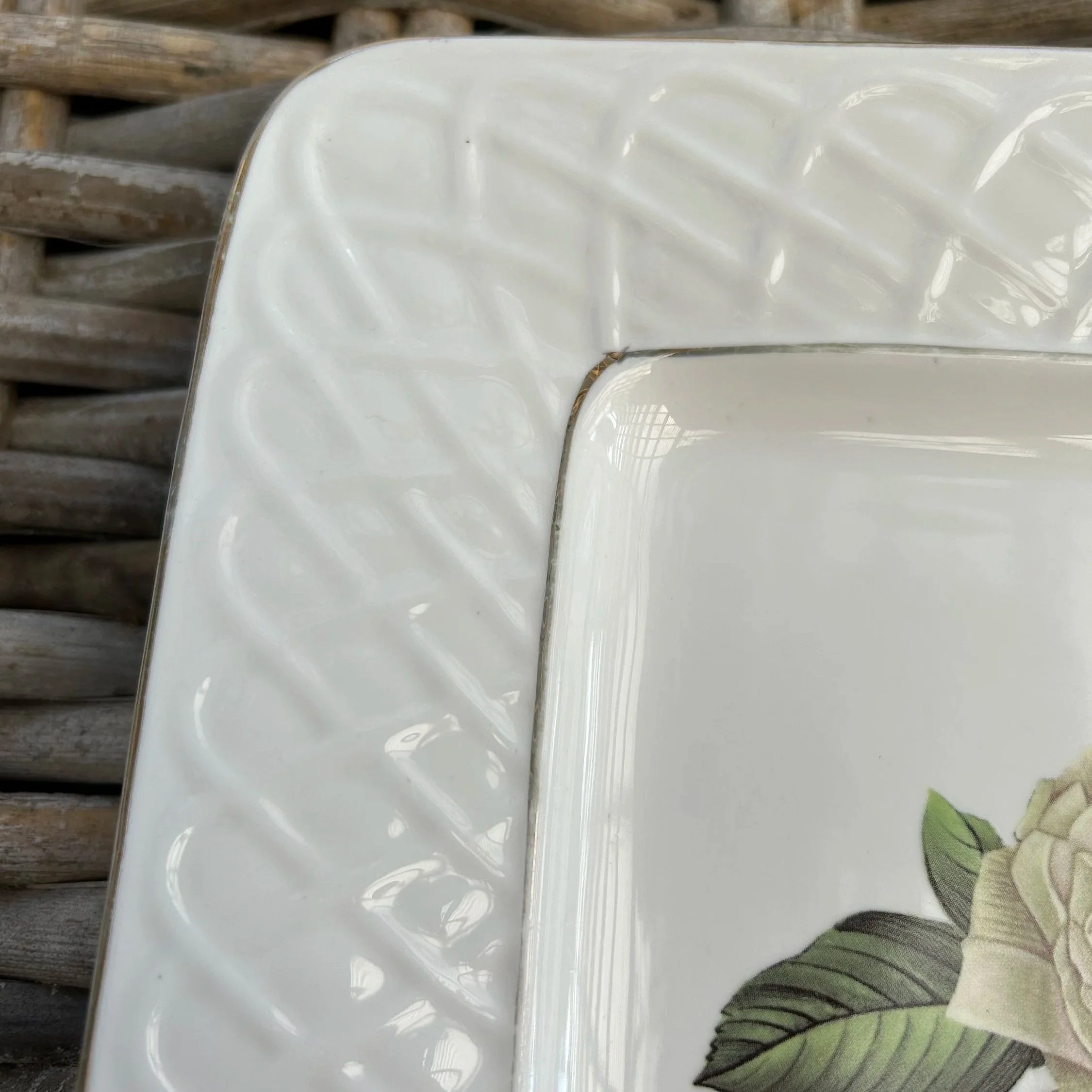 Corner detail showing raised basket weave pattern and curved gold-trimmed edge