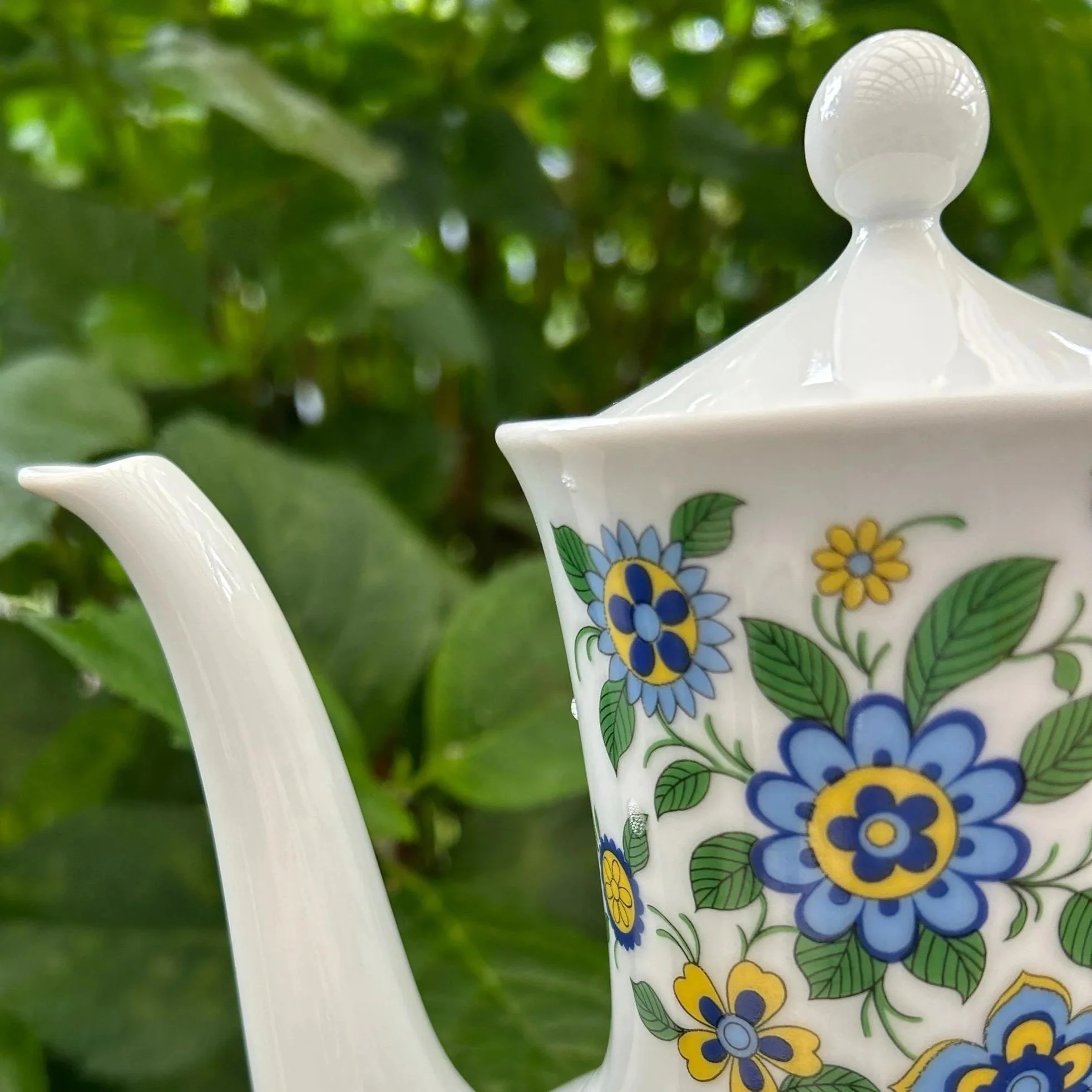 Side view highlighting spout and floral design