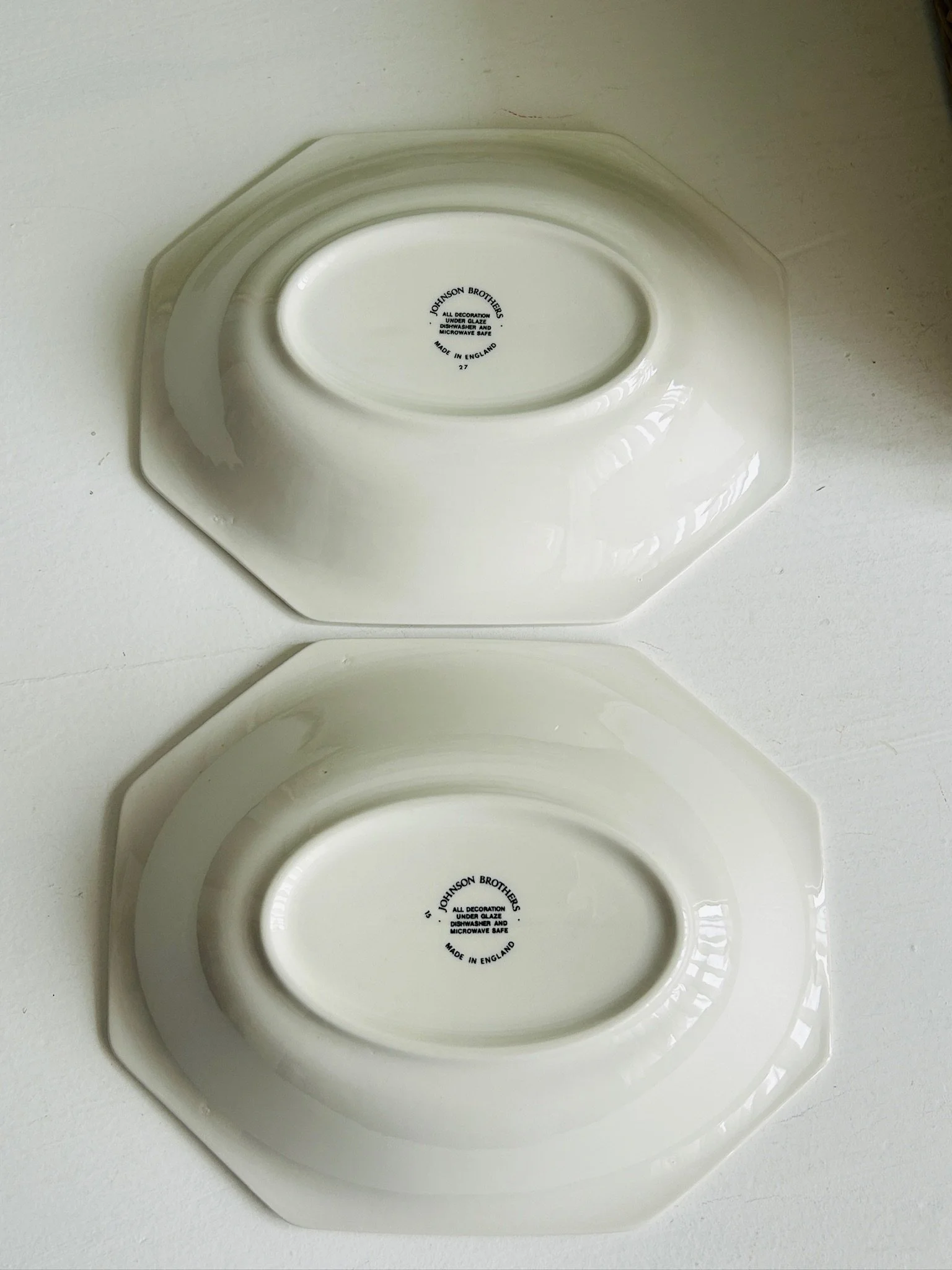 Underside view of both bowls placed face down, showing the footed bases and backstamps.