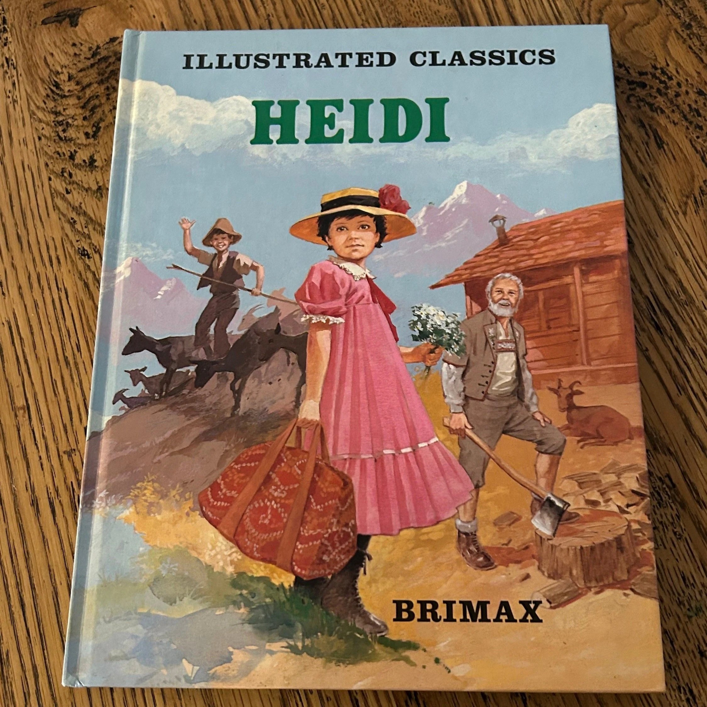 Front cover of Heidi illustrated edition, showing girl in pink dress and mountain scene