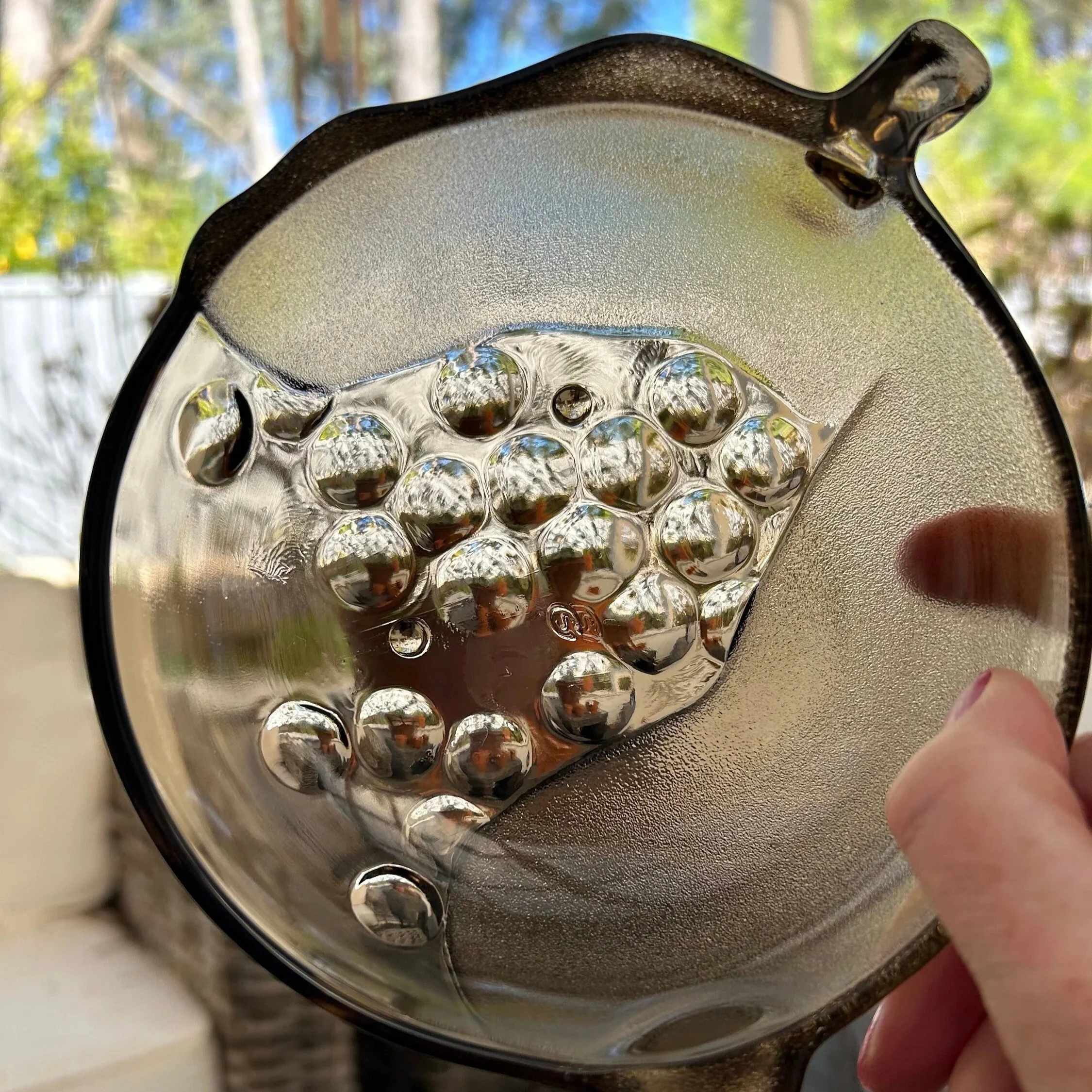 Close-up of textured base showing raised bubble design and smoky glass tone