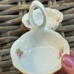 Side angle of cellar held in hand showing handle and dish shape