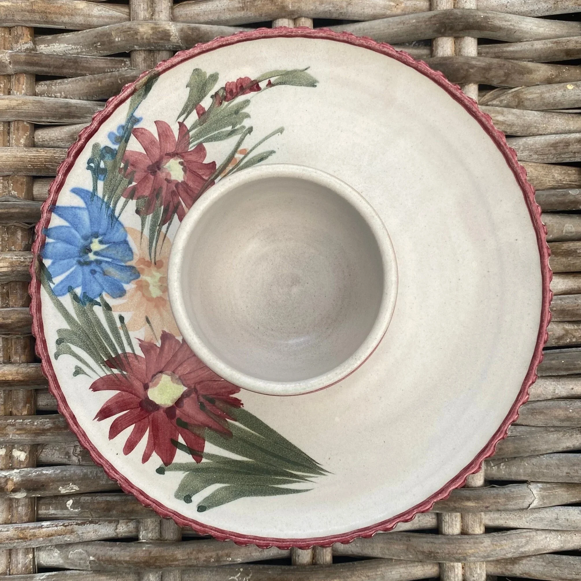 Overhead view of stoneware chip and dip bowl with hand-painted floral rim and central dip bowl