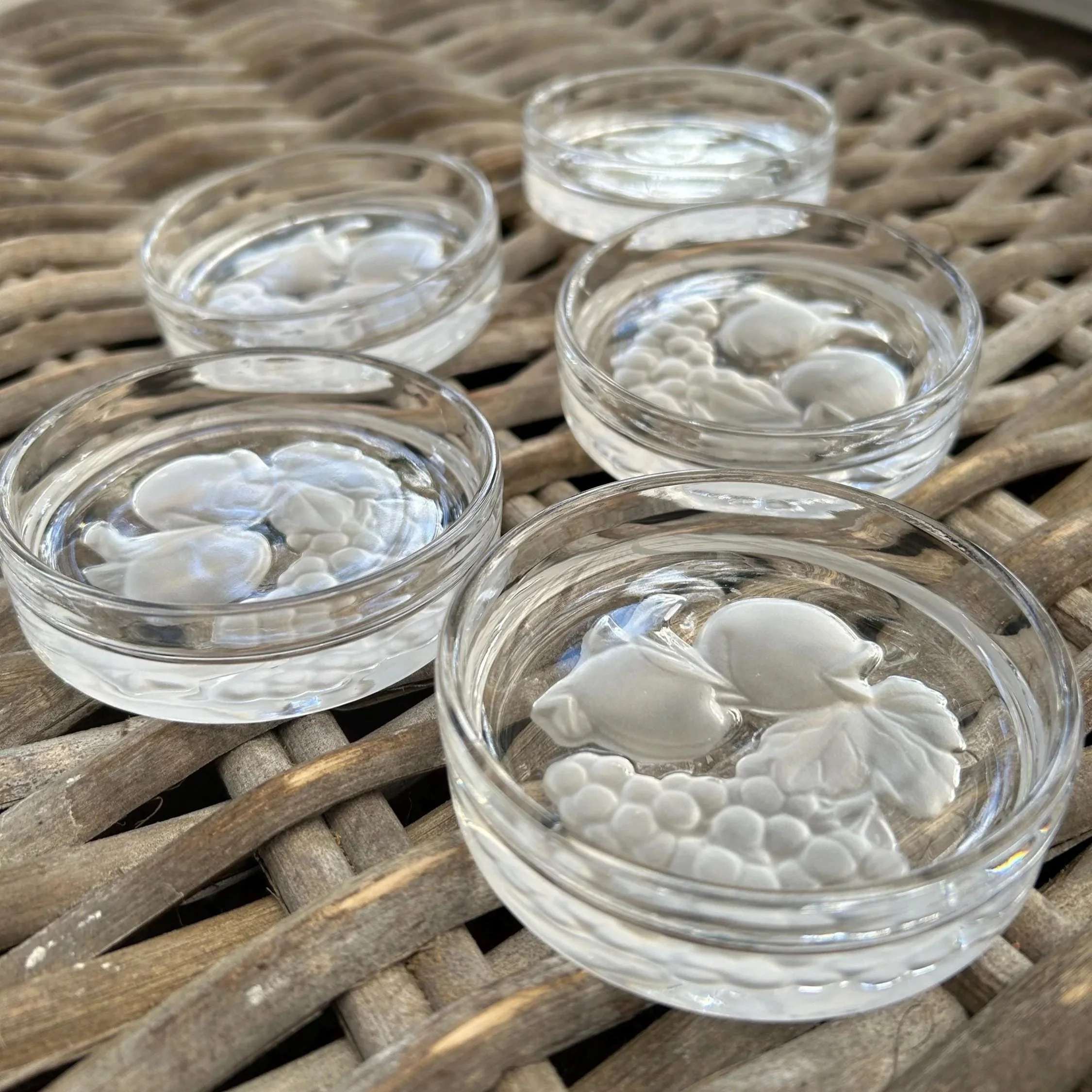 Angled view of full set of 5 crystal coasters with frosted fruit motif