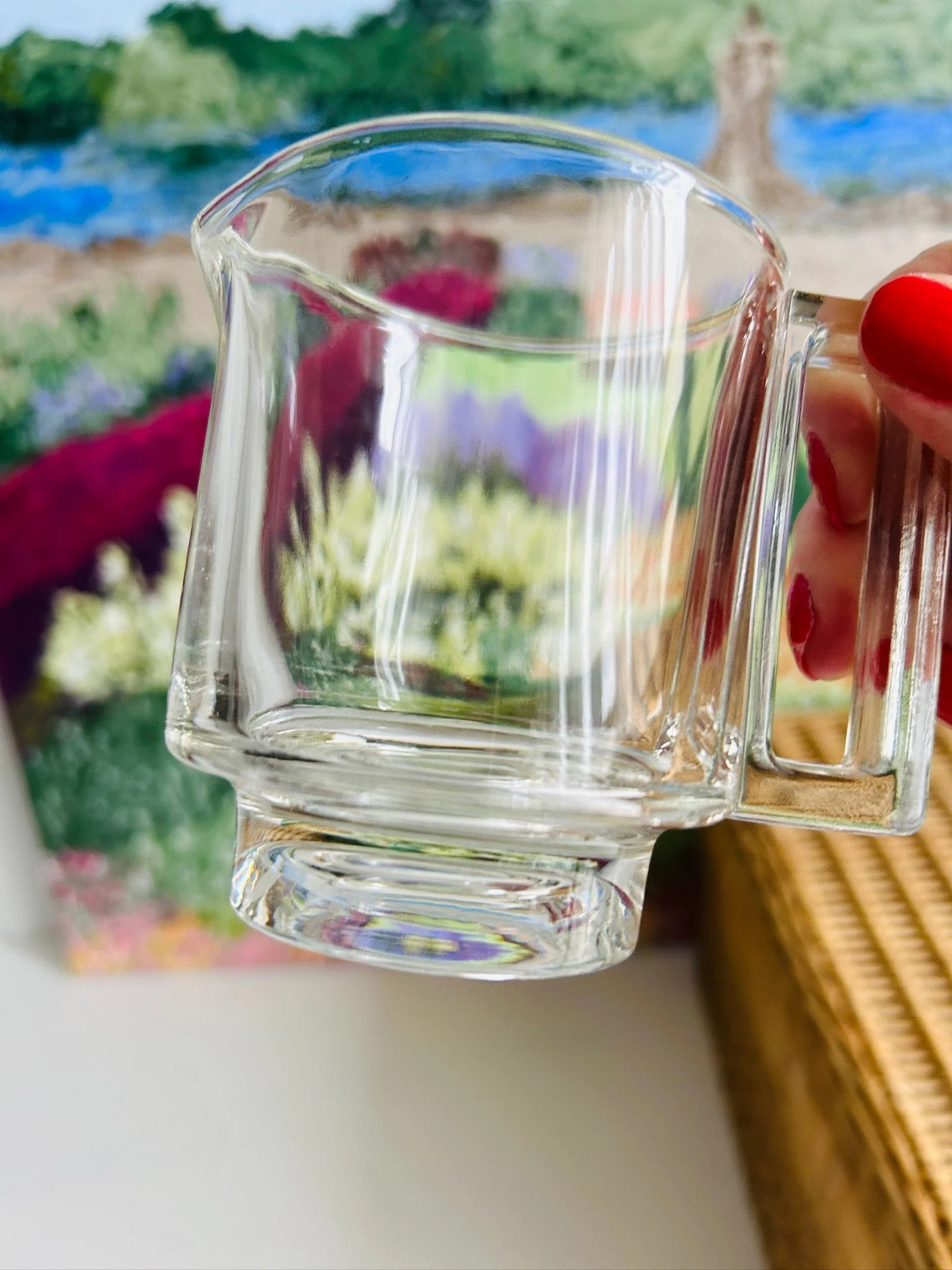 Side profile of the vintage Italian glass creamer held in hand, showing the pouring spout, thick glass walls, and squared handle