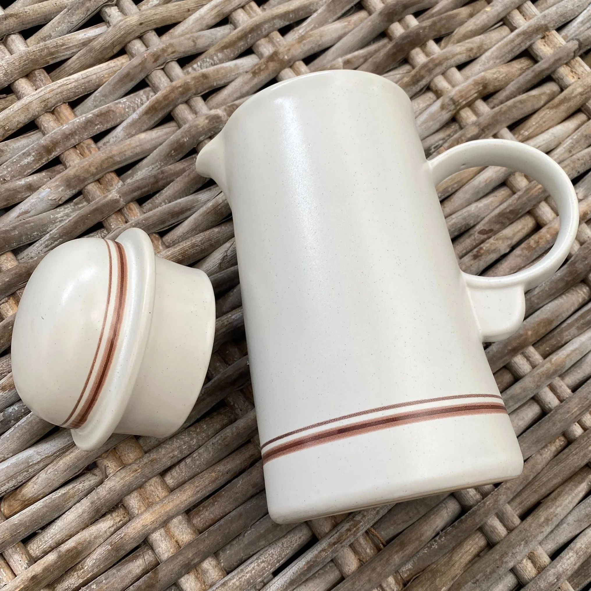 Coffee pot with lid removed, angled view on rattan surface