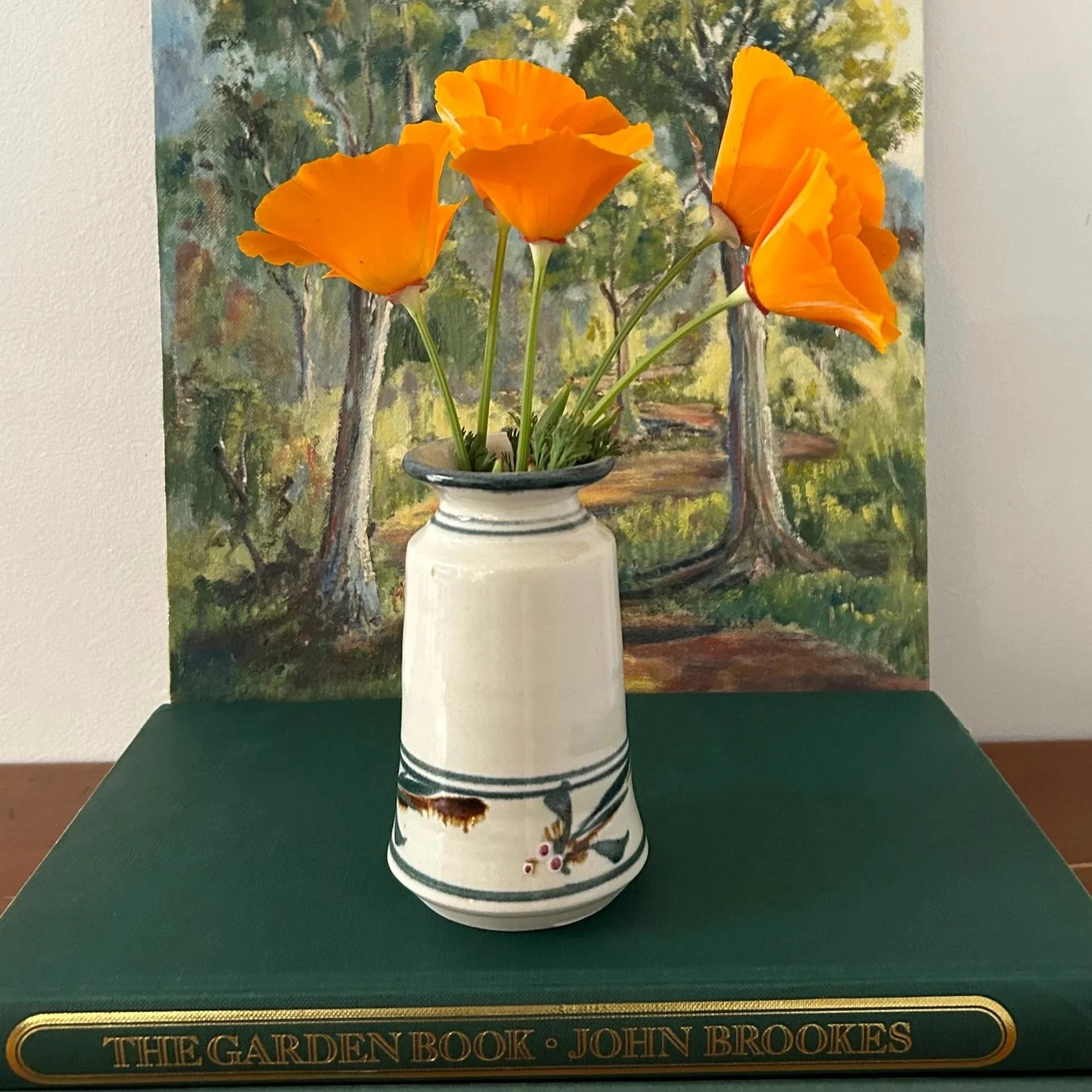 Front view of Gellibrand vase with floral design, set against a nature painting