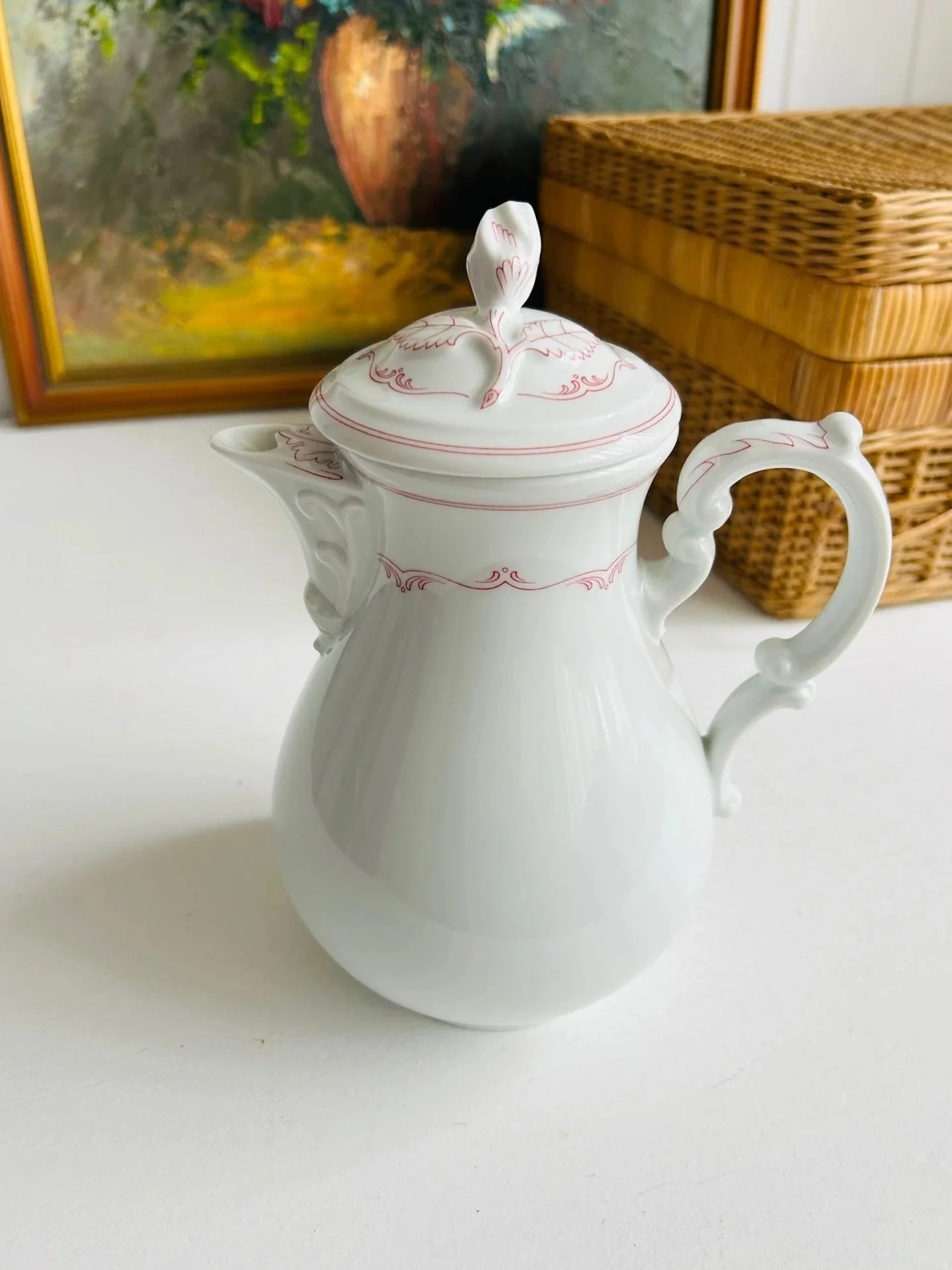 Front view of vintage Hutschenreuther Maria Theresia Mainau coffee pot in white porcelain with delicate red floral detailing and leaf-shaped lid finial.
