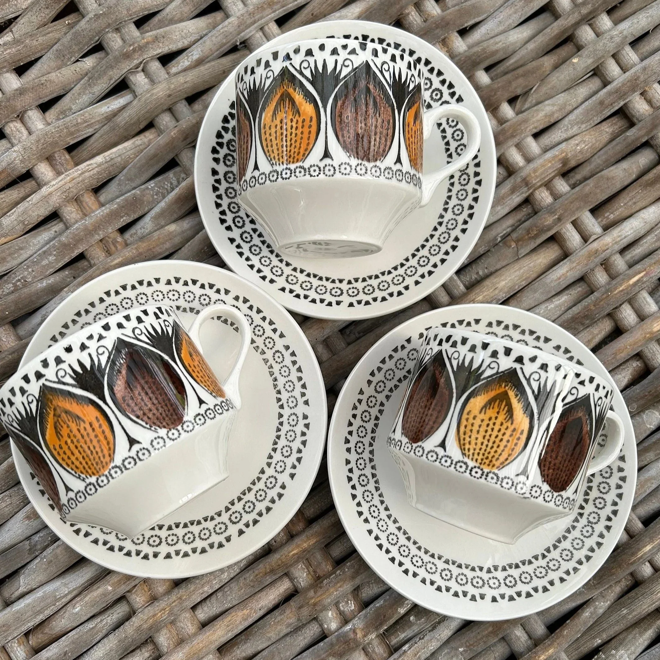 Full overhead view of 3 Broadhurst Ironstone cup and saucer sets with geometric border and autumn tulip design