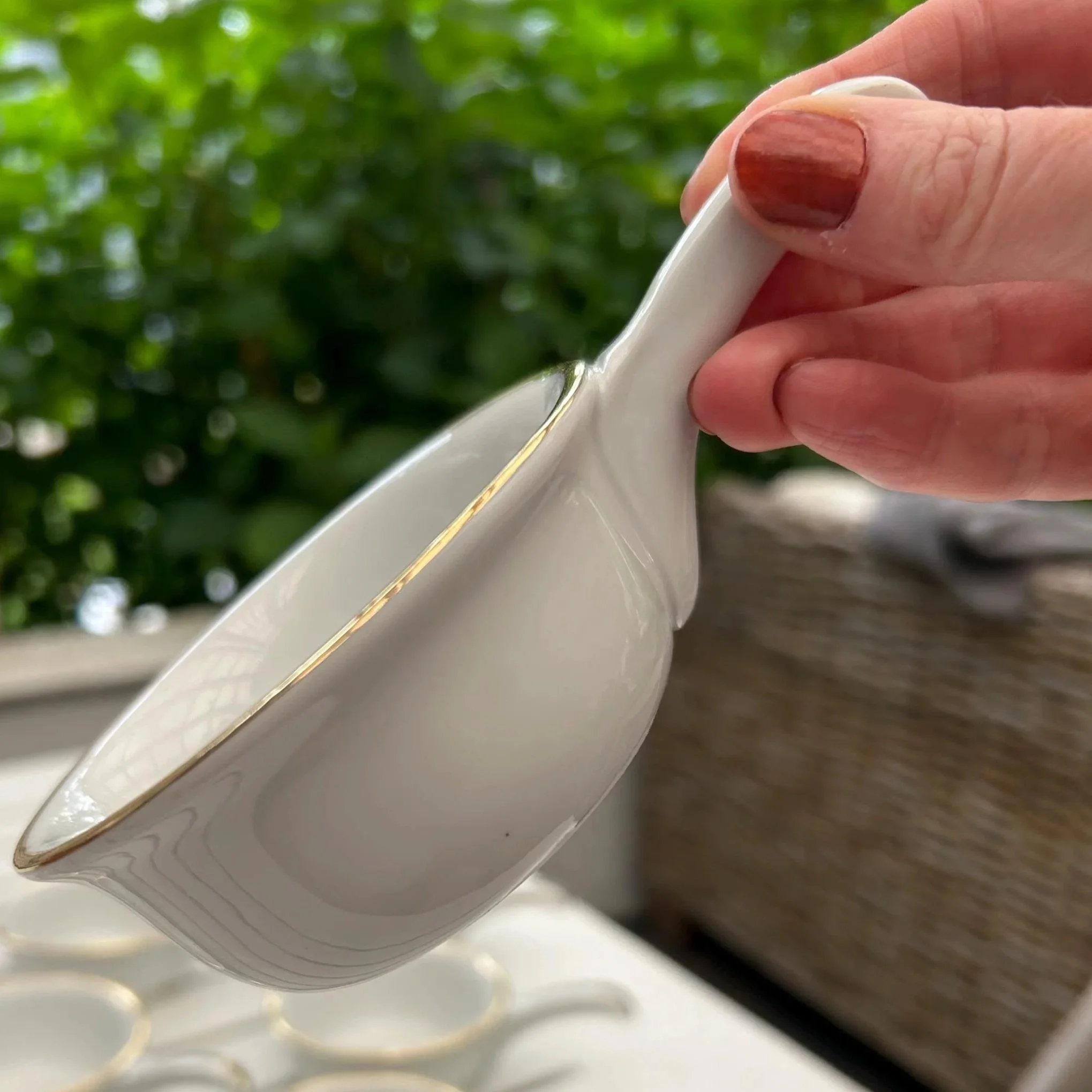 Angled view showing flared lip and elegant gold-edged handle