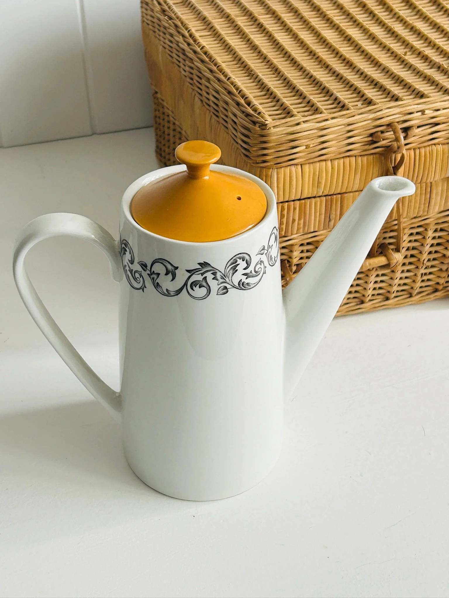 Three-quarter view of the vintage English coffee pot with orange lid in place, showing the full profile, spout, handle, and decorative black rim pattern.