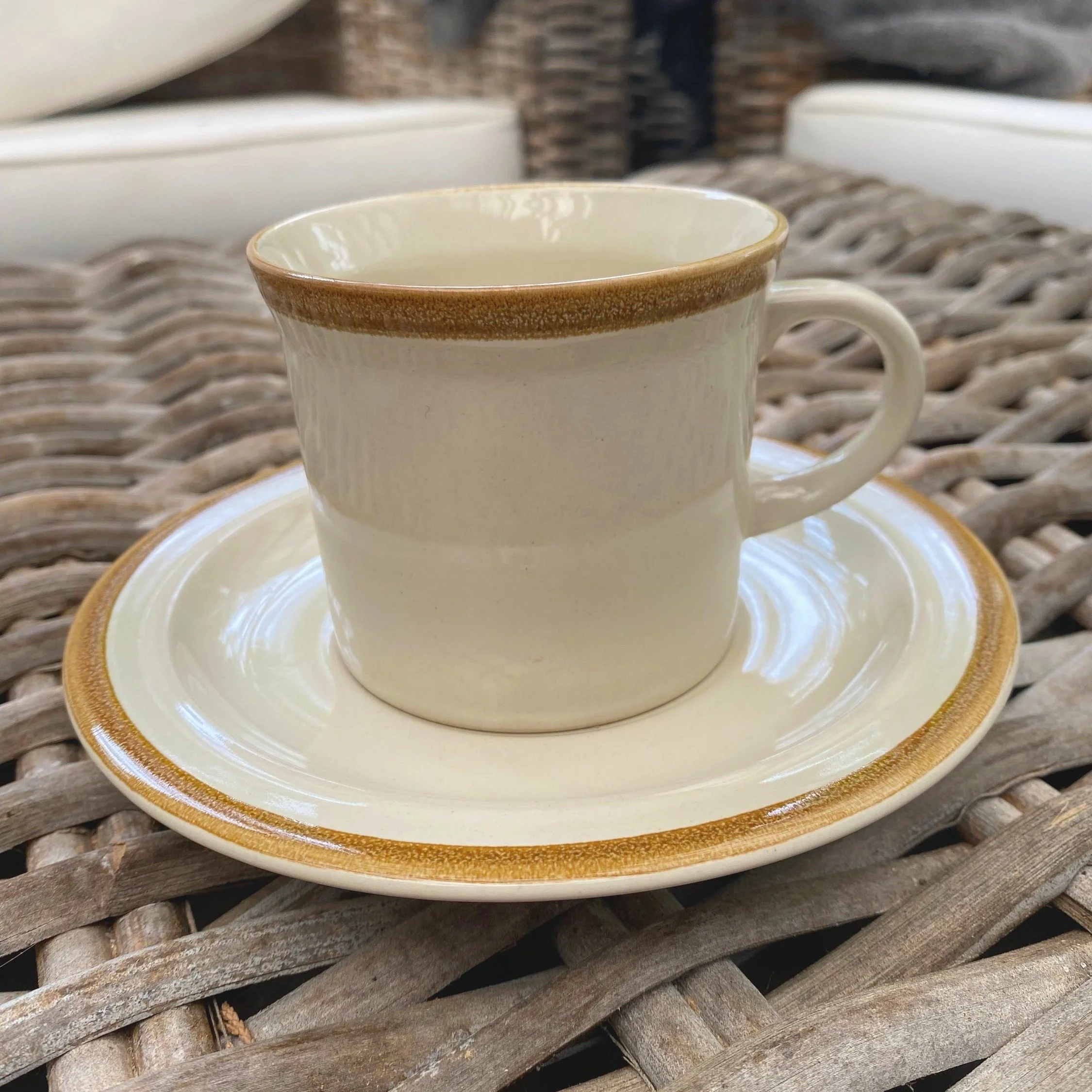 JI Stonecrest cup and saucer duo by Andre Sonche, beige with caramel brown trim. Vintage stoneware, crafted in Korea (1970s).