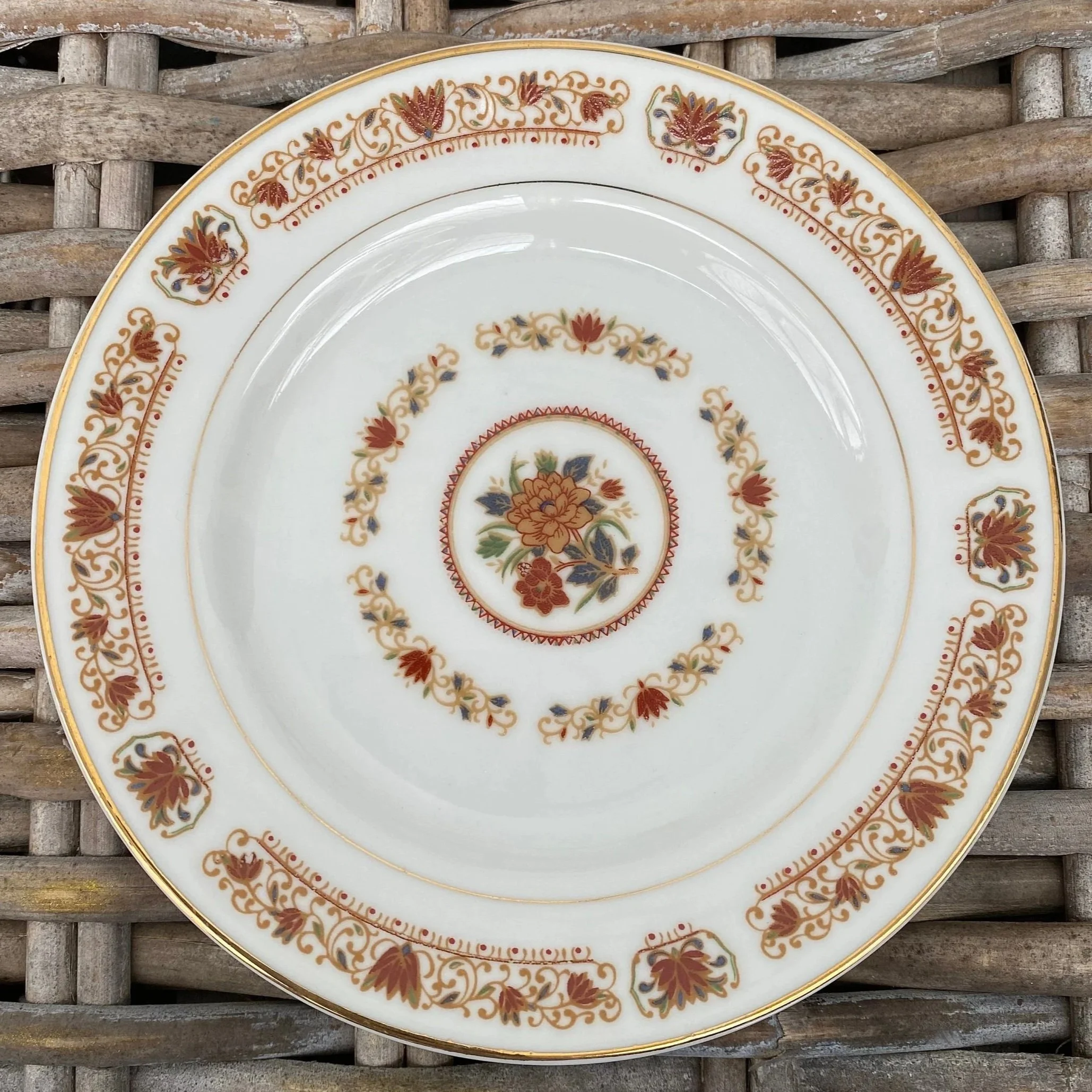 Overhead view of small plate with rust and gold lotus design