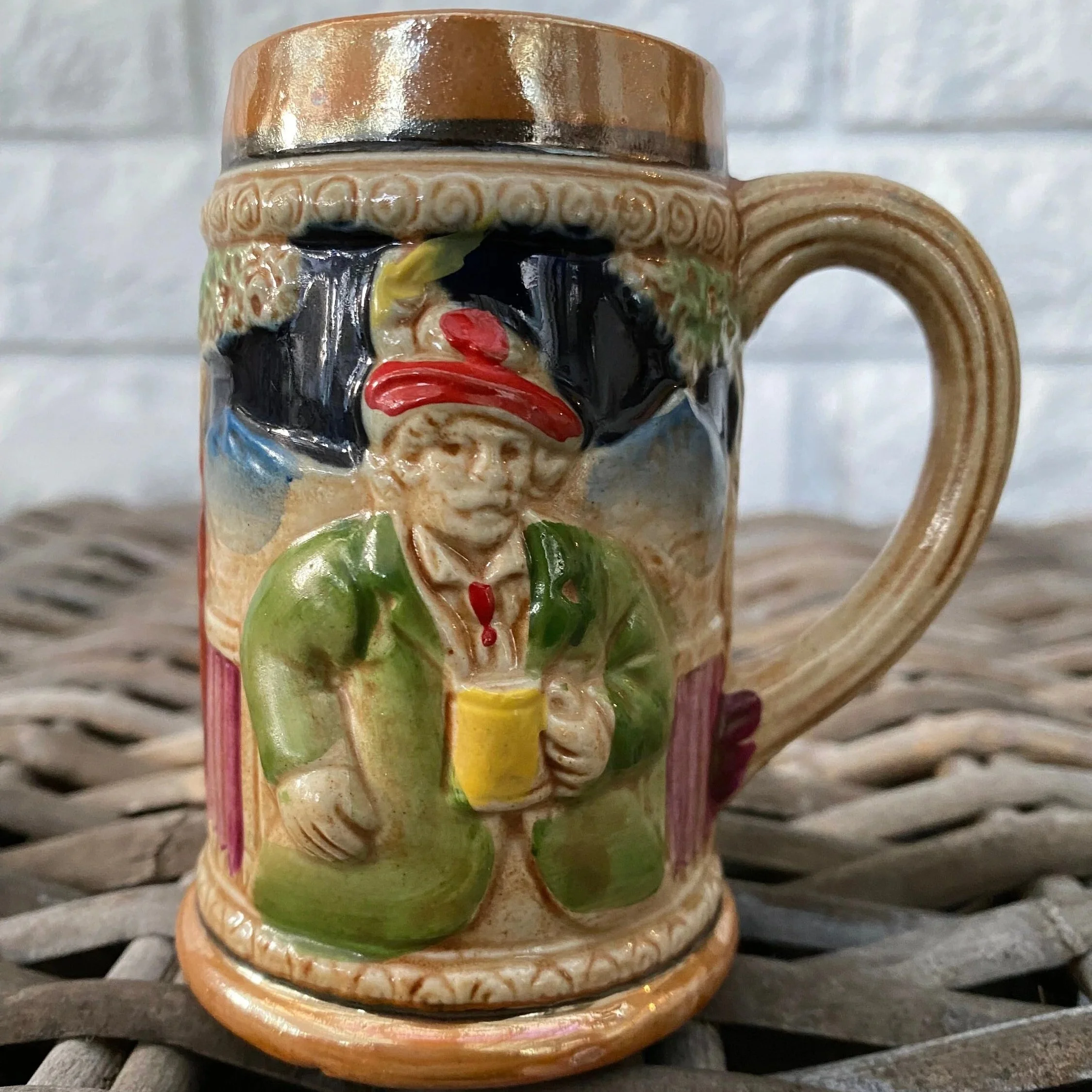 Single tankard front view with colourful relief man and scenic background.