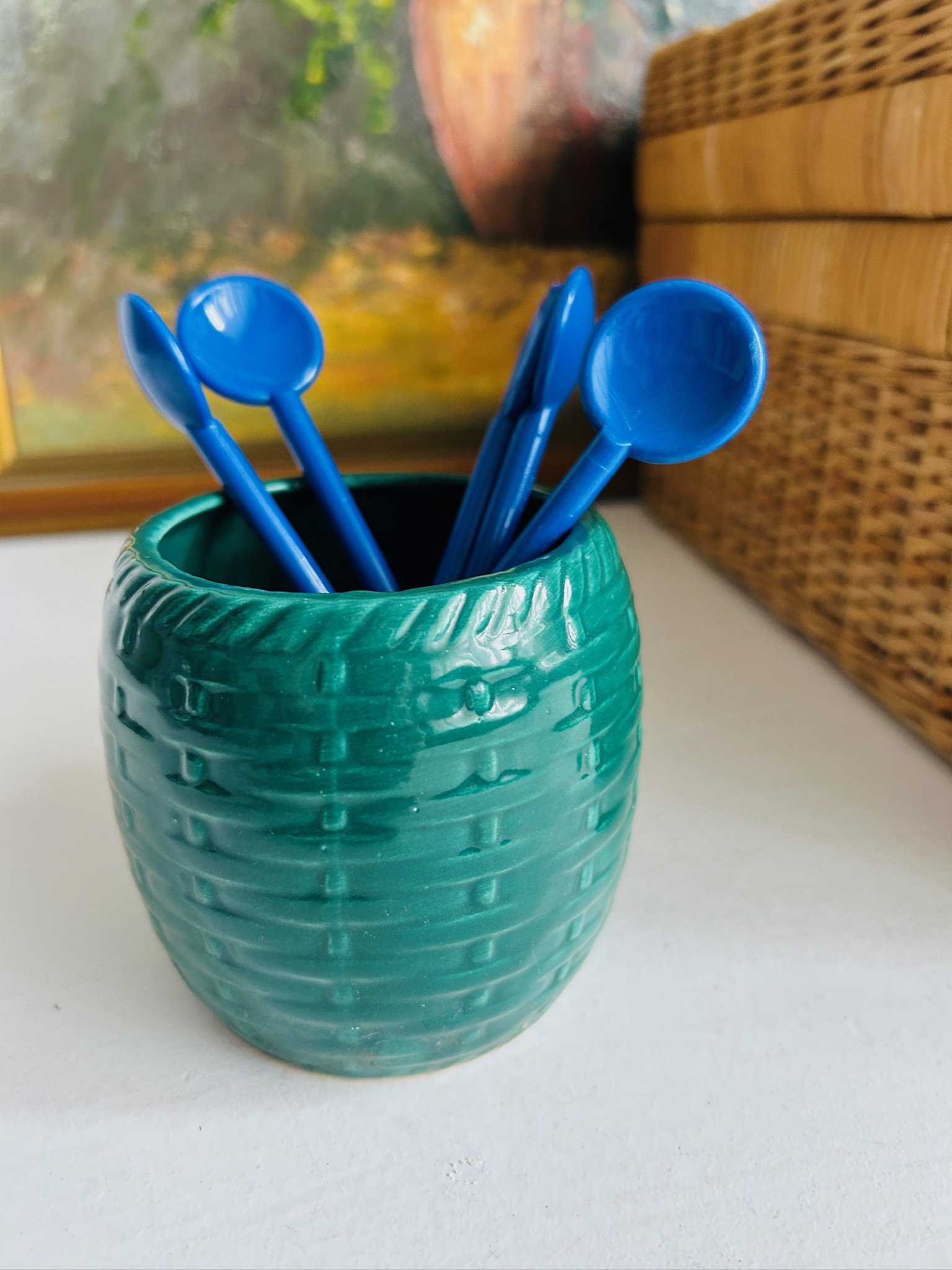 Set of blue Bodum stir spoons displayed inside a textured turquoise cup on a white surface